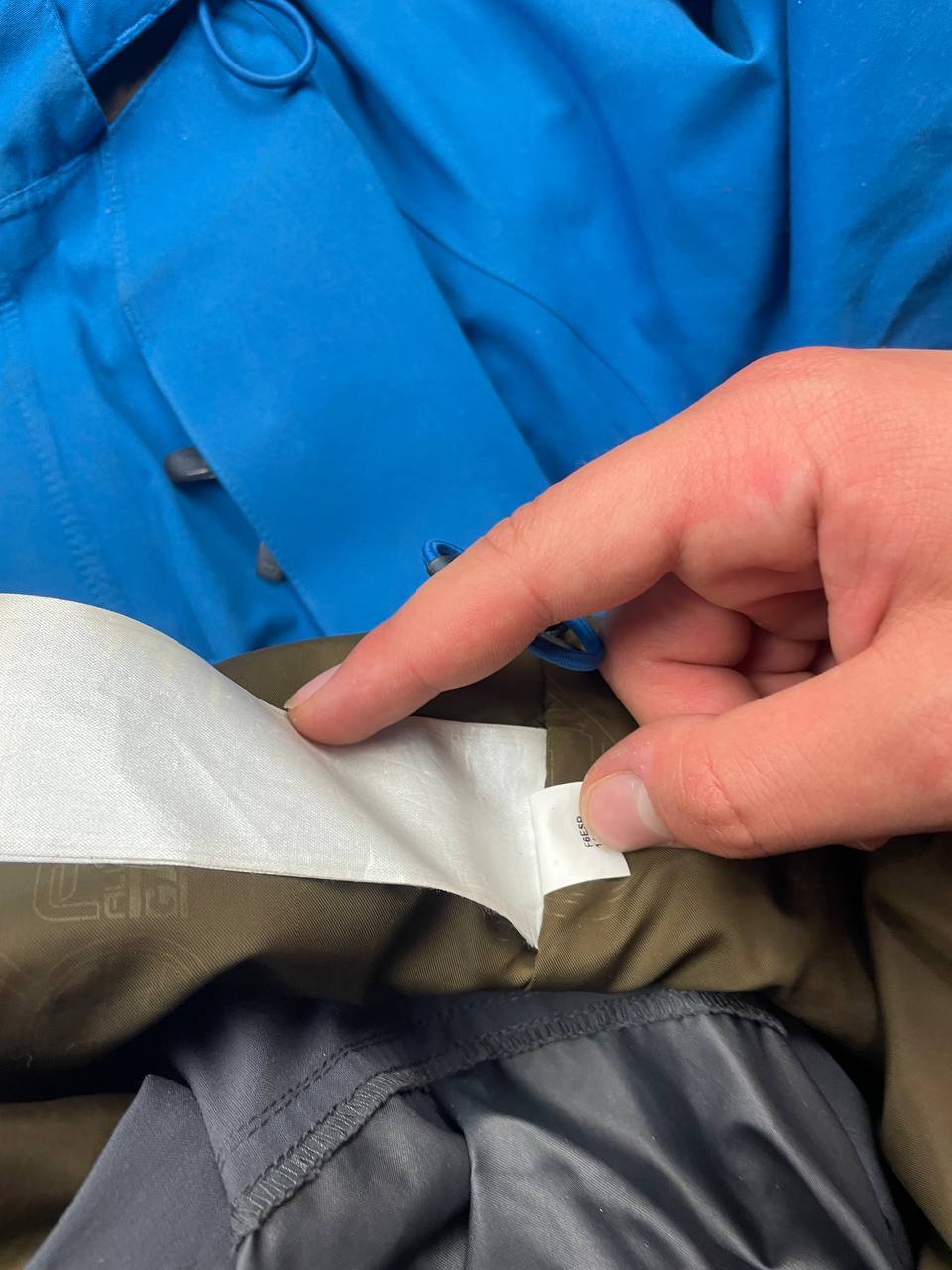 Nike ACG blue and brown waterproof jacket with Gore-Tex label and adjustable hood.