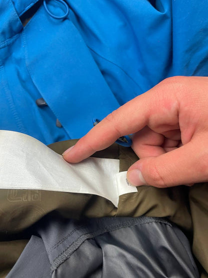 Nike ACG blue and brown waterproof jacket with Gore-Tex label and adjustable hood.