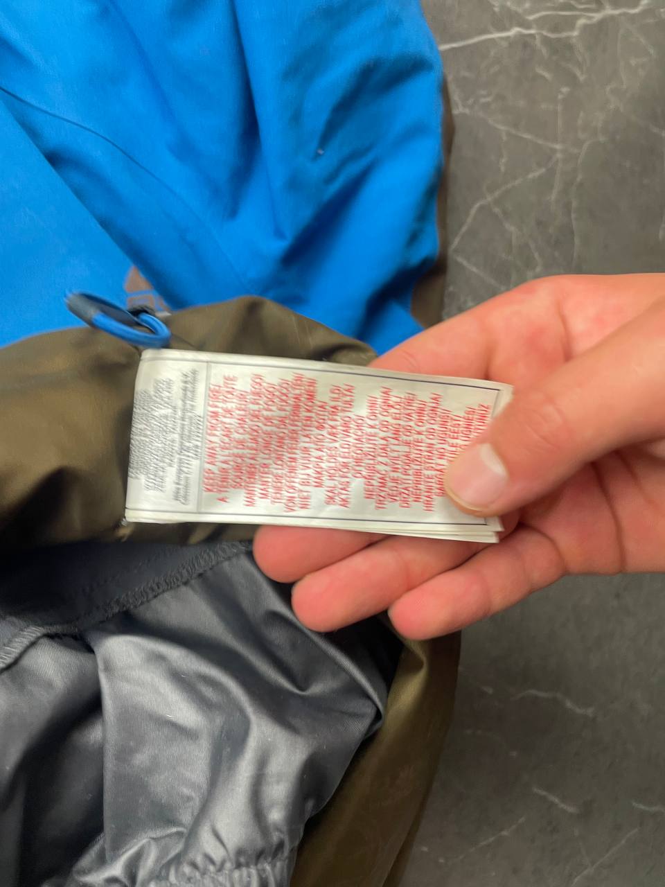 Nike ACG blue and brown waterproof jacket with Gore-Tex label and adjustable hood.