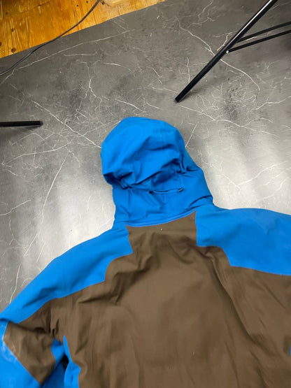Nike ACG blue and brown waterproof jacket with Gore-Tex label and adjustable hood.
