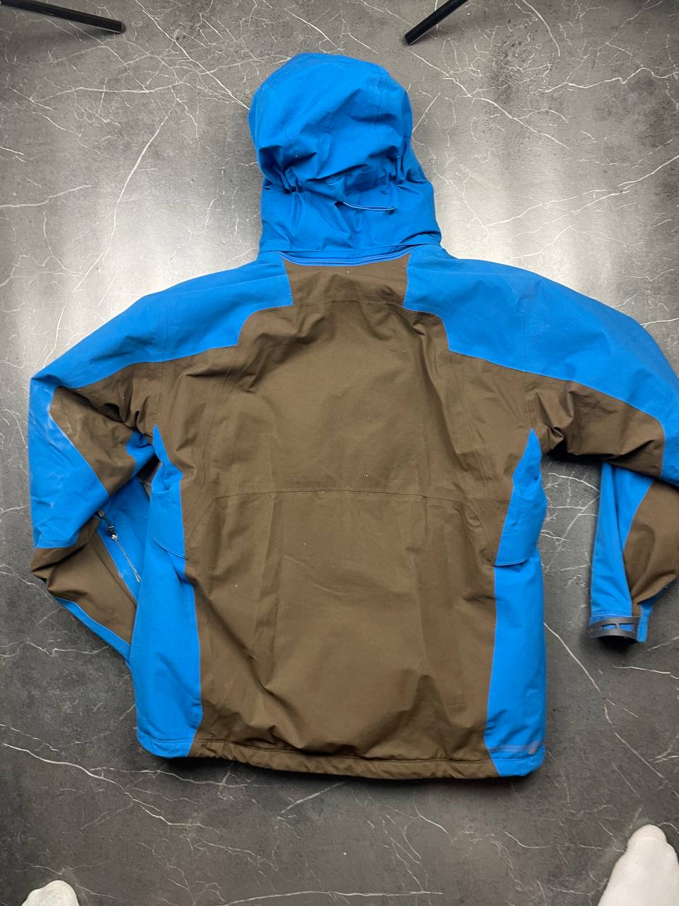 Nike ACG blue and brown waterproof jacket with Gore-Tex label and adjustable hood.