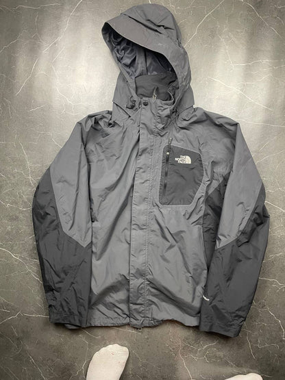 The North Face black and grey waterproof jacket with hood and chest pocket.