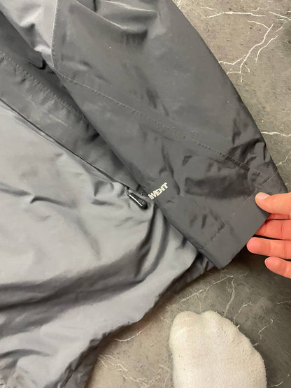 The North Face black and grey waterproof jacket with hood and chest pocket.