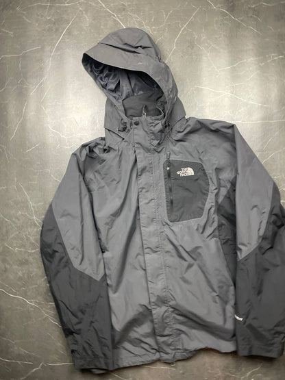 The North Face black and grey waterproof jacket with hood and chest pocket.
