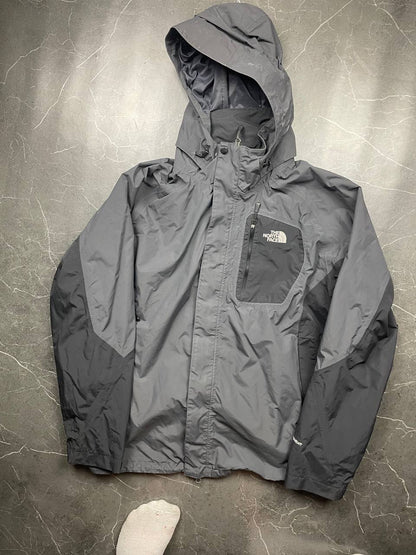 The North Face black and grey waterproof jacket with hood and chest pocket.