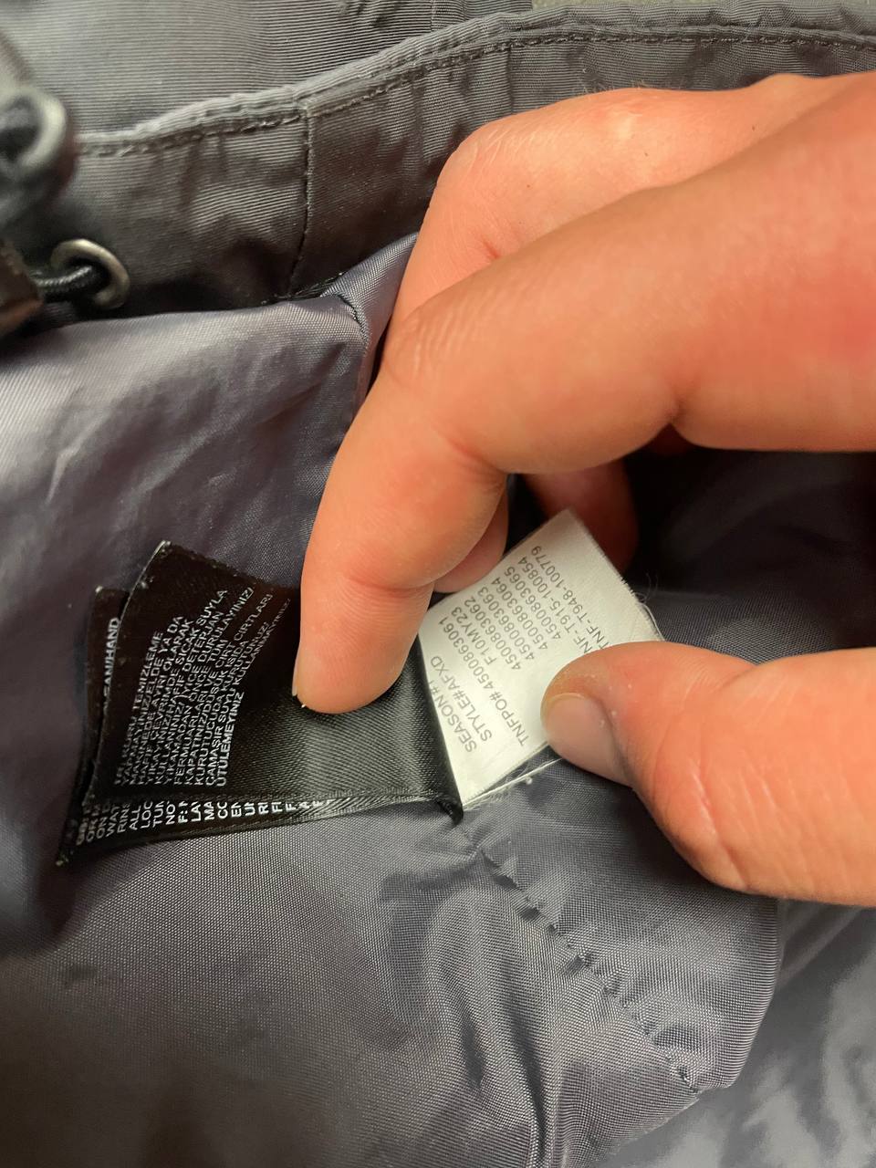 The North Face black and grey waterproof jacket with hood and chest pocket.