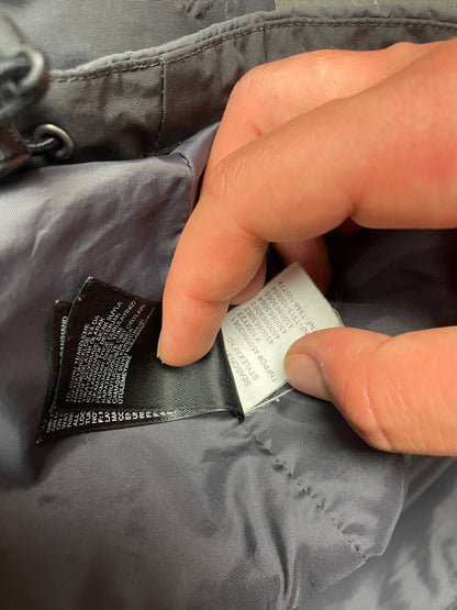 The North Face black and grey waterproof jacket with hood and chest pocket.
