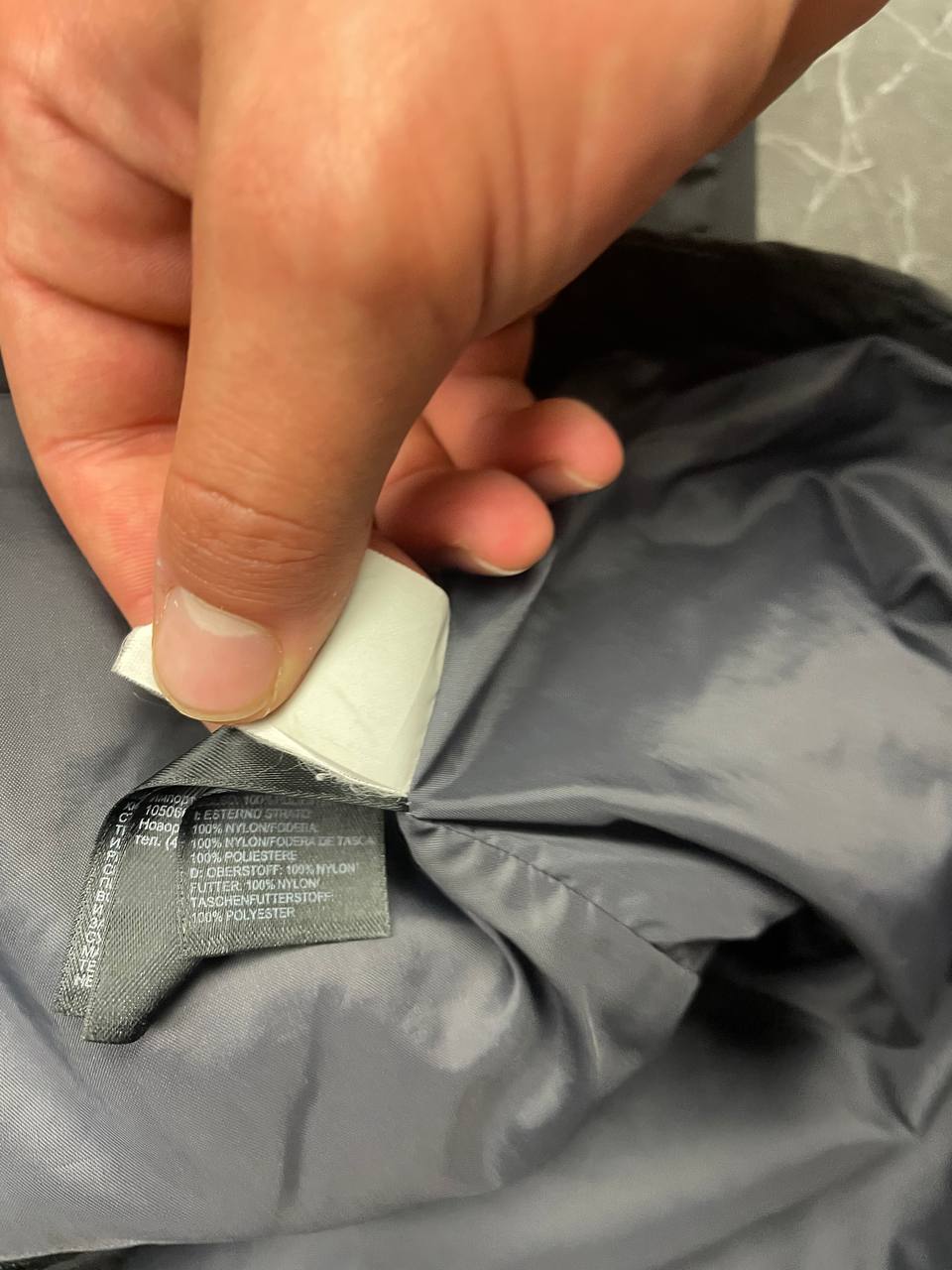 The North Face black and grey waterproof jacket with hood and chest pocket.