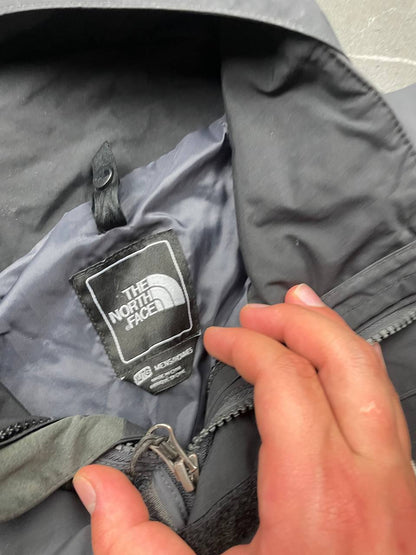 The North Face black and grey waterproof jacket with hood and chest pocket.