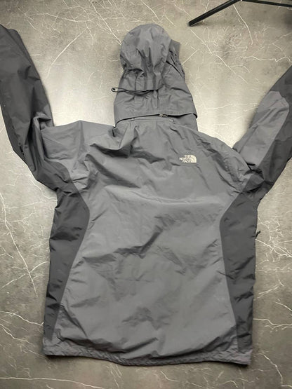 The North Face black and grey waterproof jacket with hood and chest pocket.