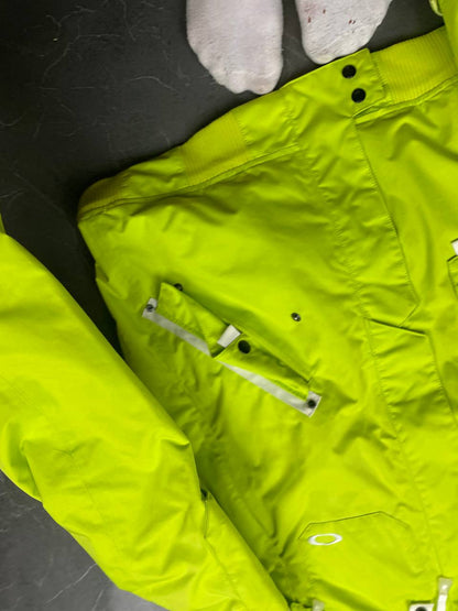 Oakley lime green ski jacket with hood, multicolored interior lining, logo on chest.