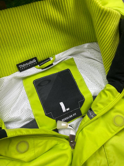 Oakley lime green ski jacket with hood, multicolored interior lining, logo on chest.