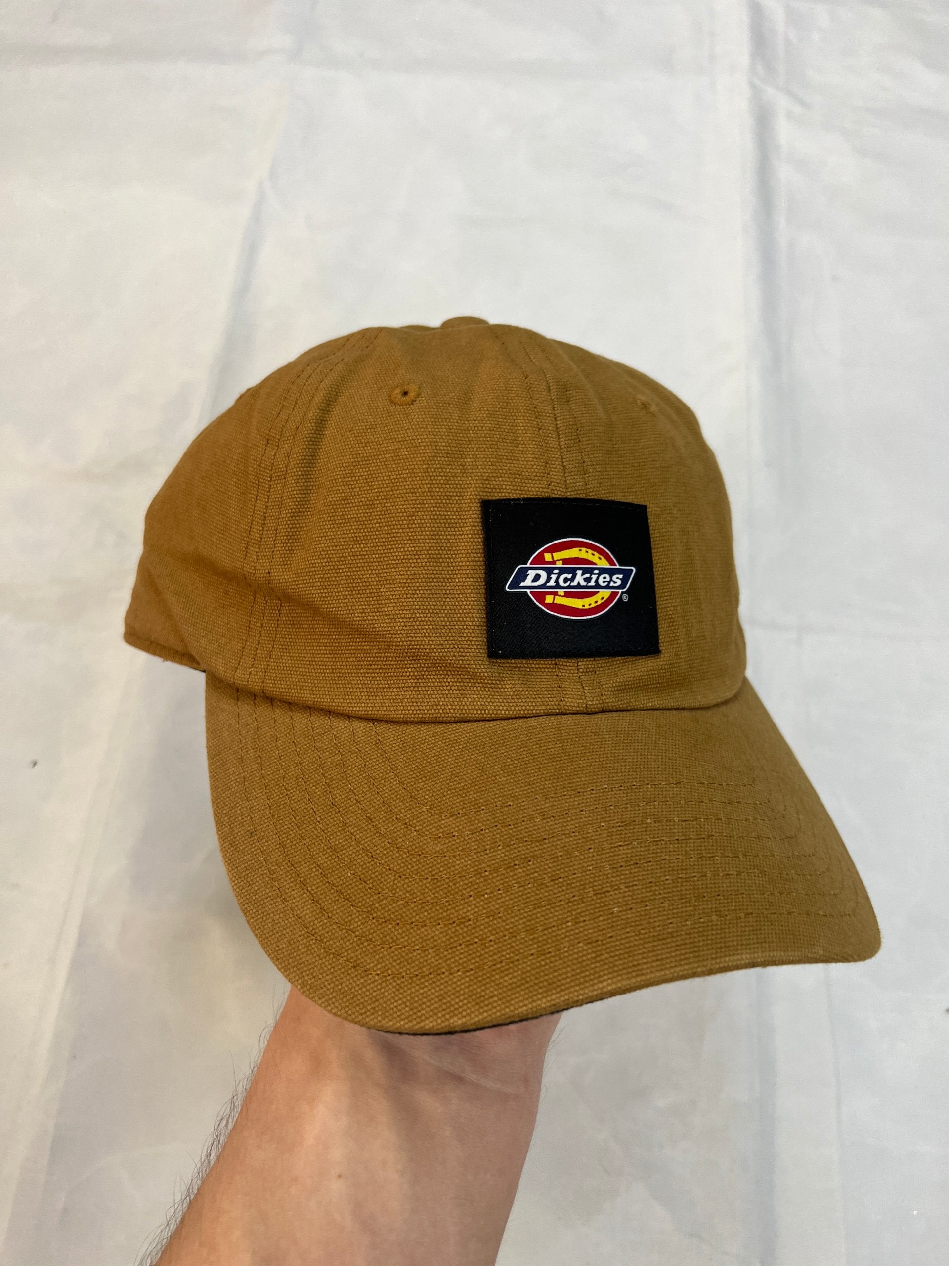 Dickies brown canvas baseball cap with logo patch and adjustable strap.