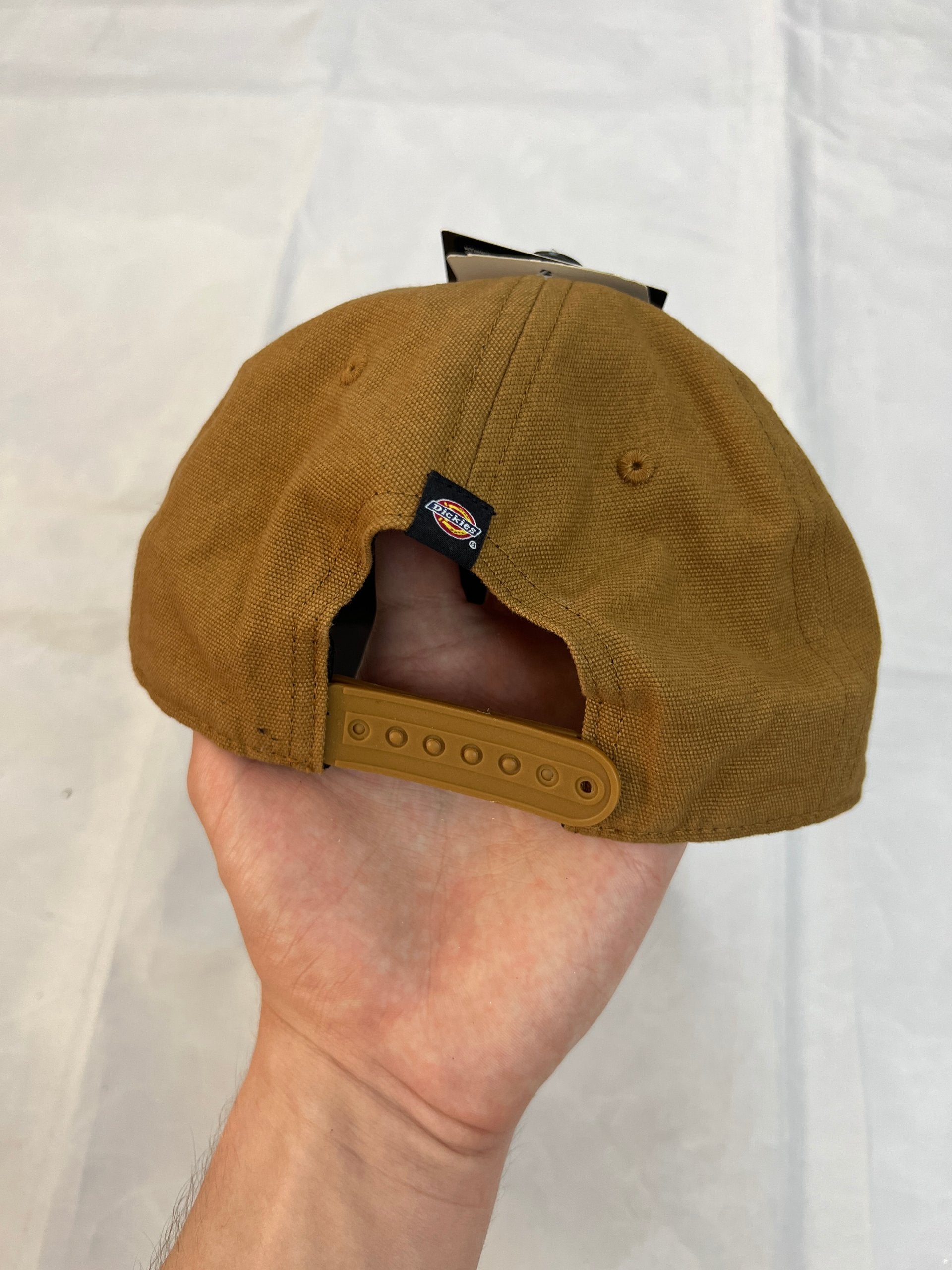 Dickies brown canvas baseball cap with logo patch and adjustable strap.