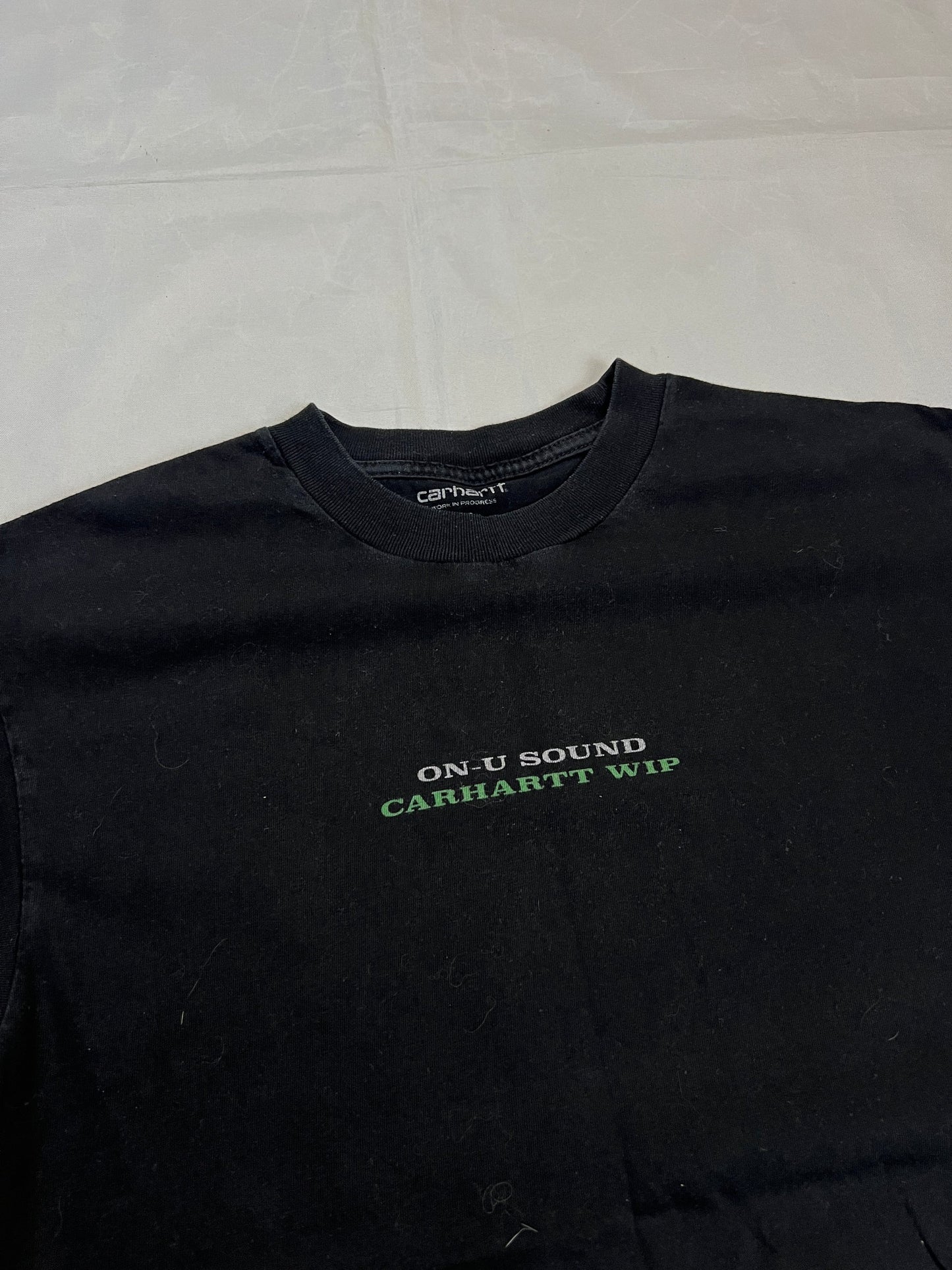 Carhartt black graphic cotton t-shirt with yellow cartoon design and printed text.