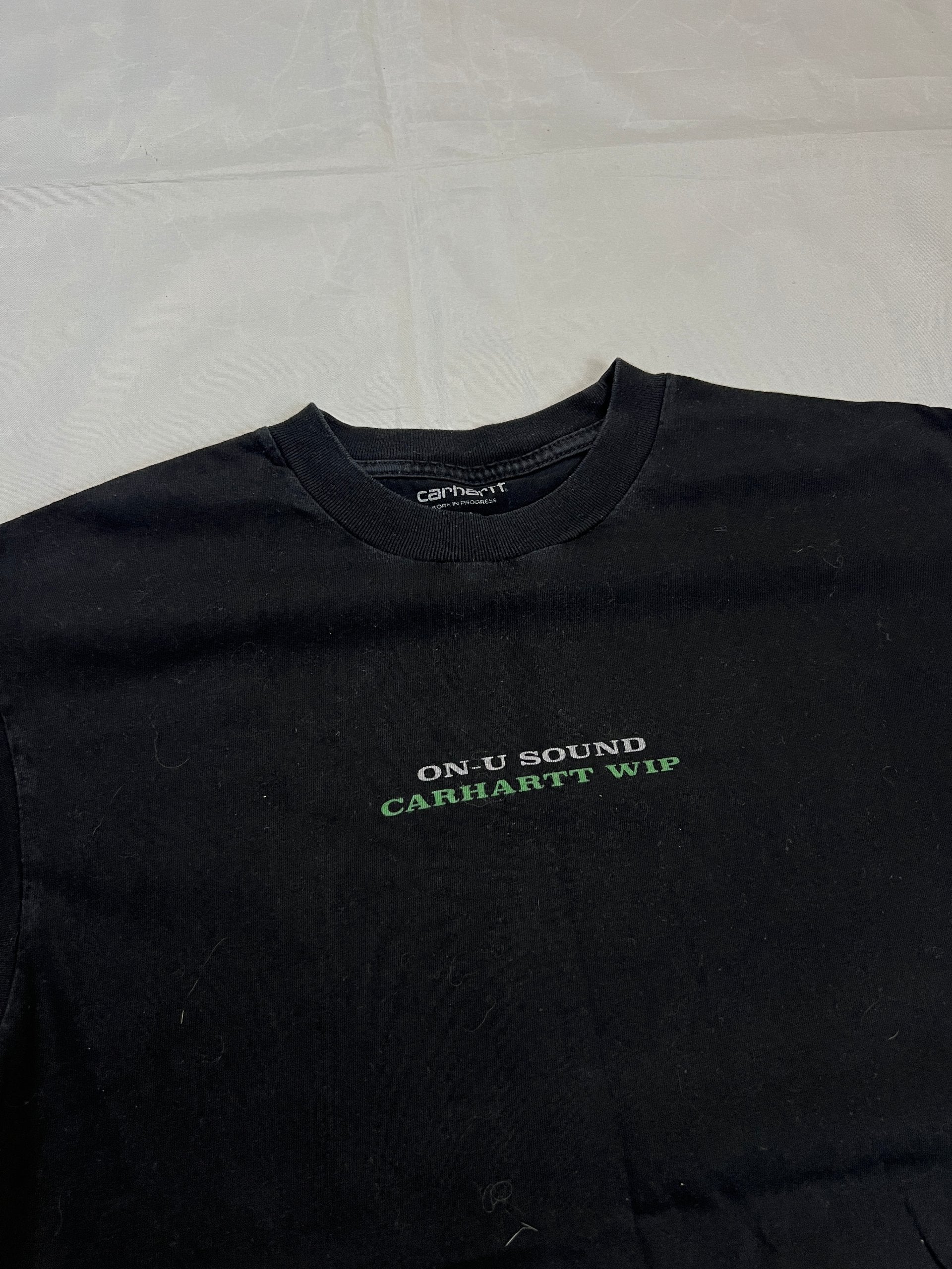 Carhartt black graphic cotton t-shirt with yellow cartoon design and printed text.