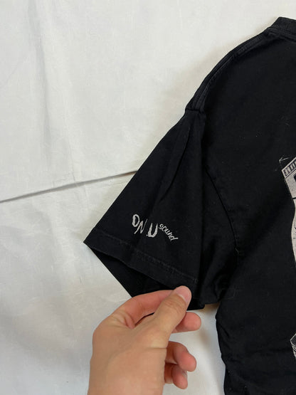 Carhartt black graphic cotton t-shirt with yellow cartoon design and printed text.