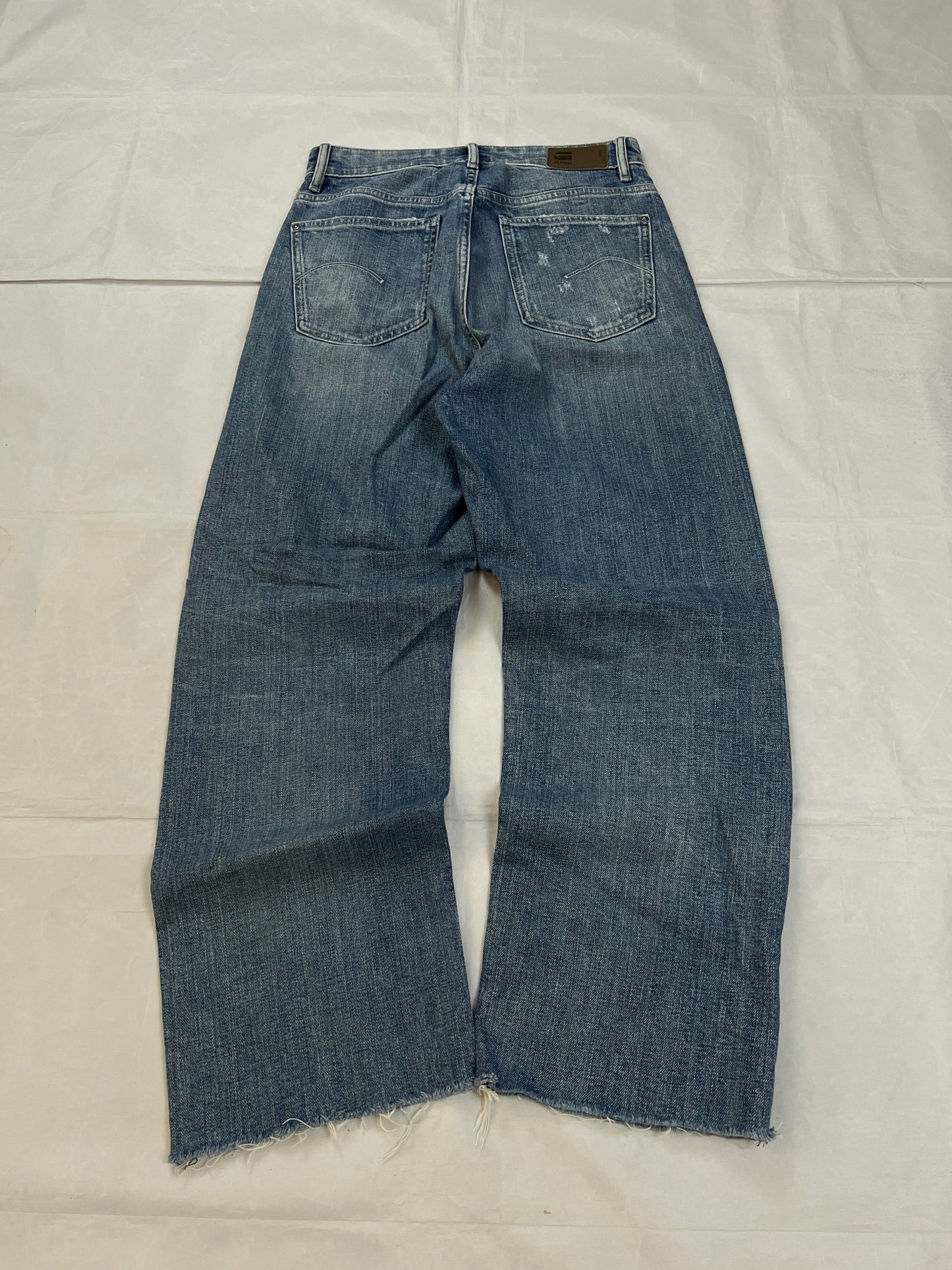 G-Star Raw blue distressed denim jeans with frayed hems and slit detail.