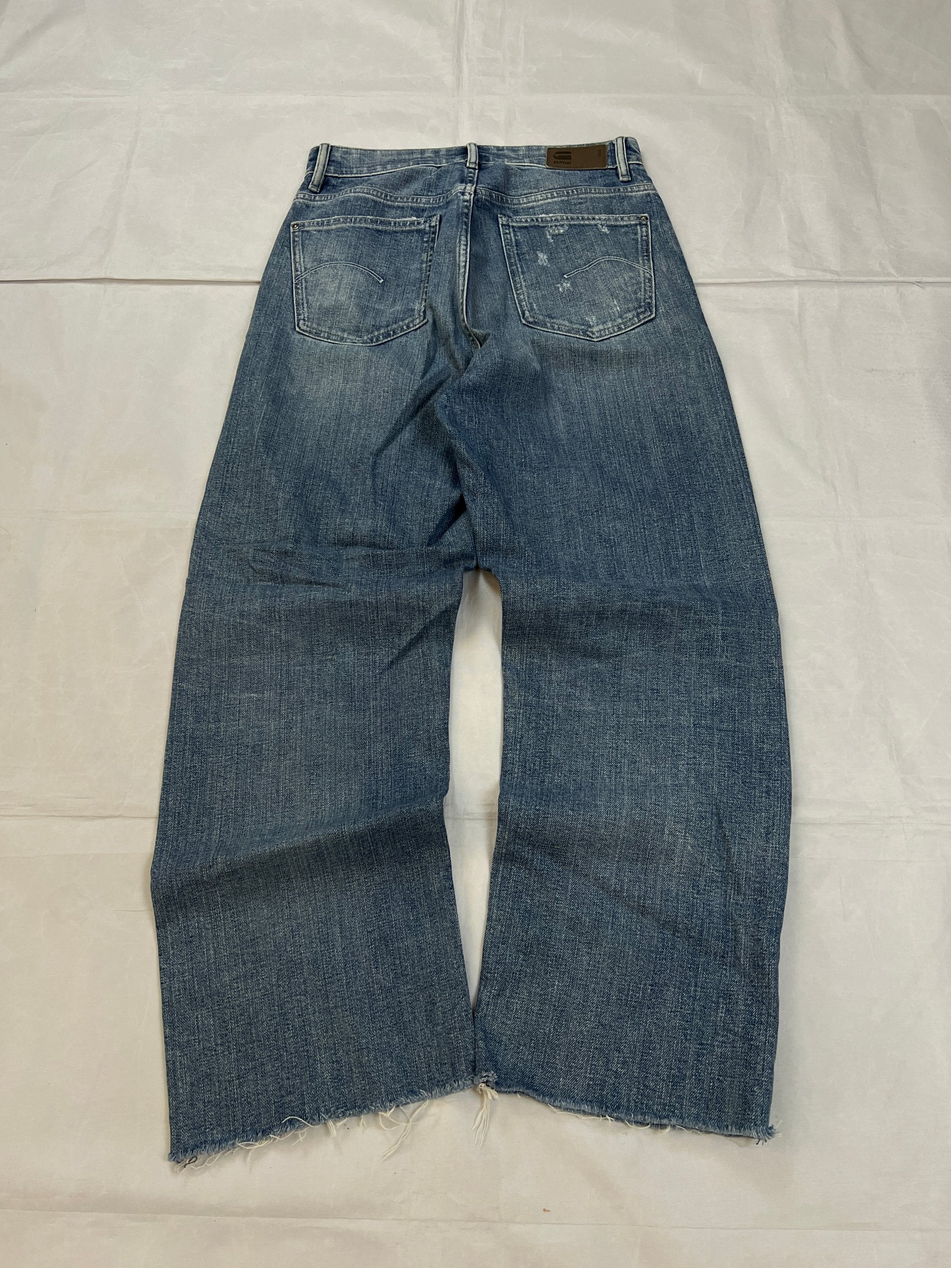 G-Star Raw blue distressed denim jeans with frayed hems and slit detail.