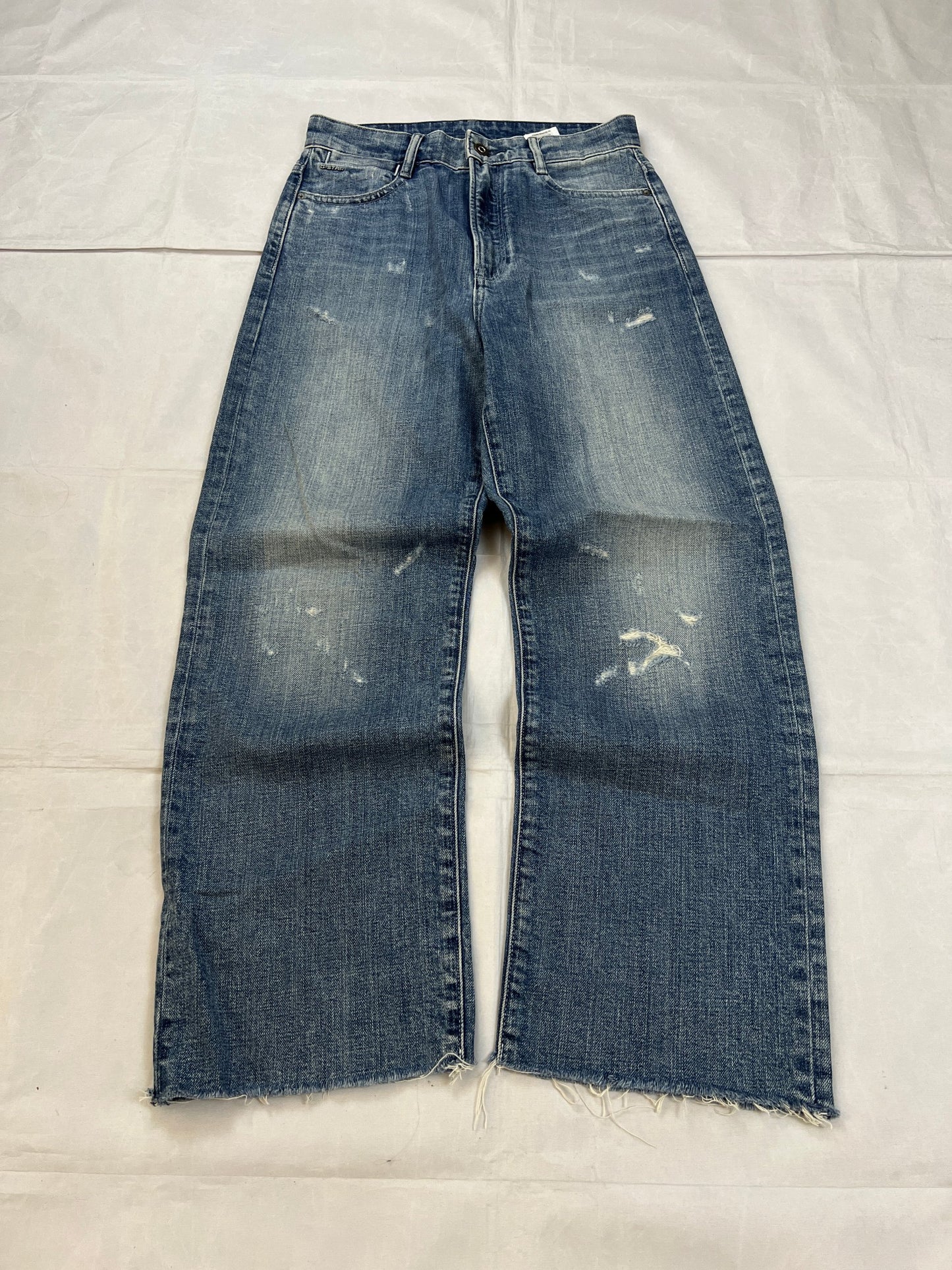 G-Star Raw blue distressed denim jeans with frayed hems and slit detail.