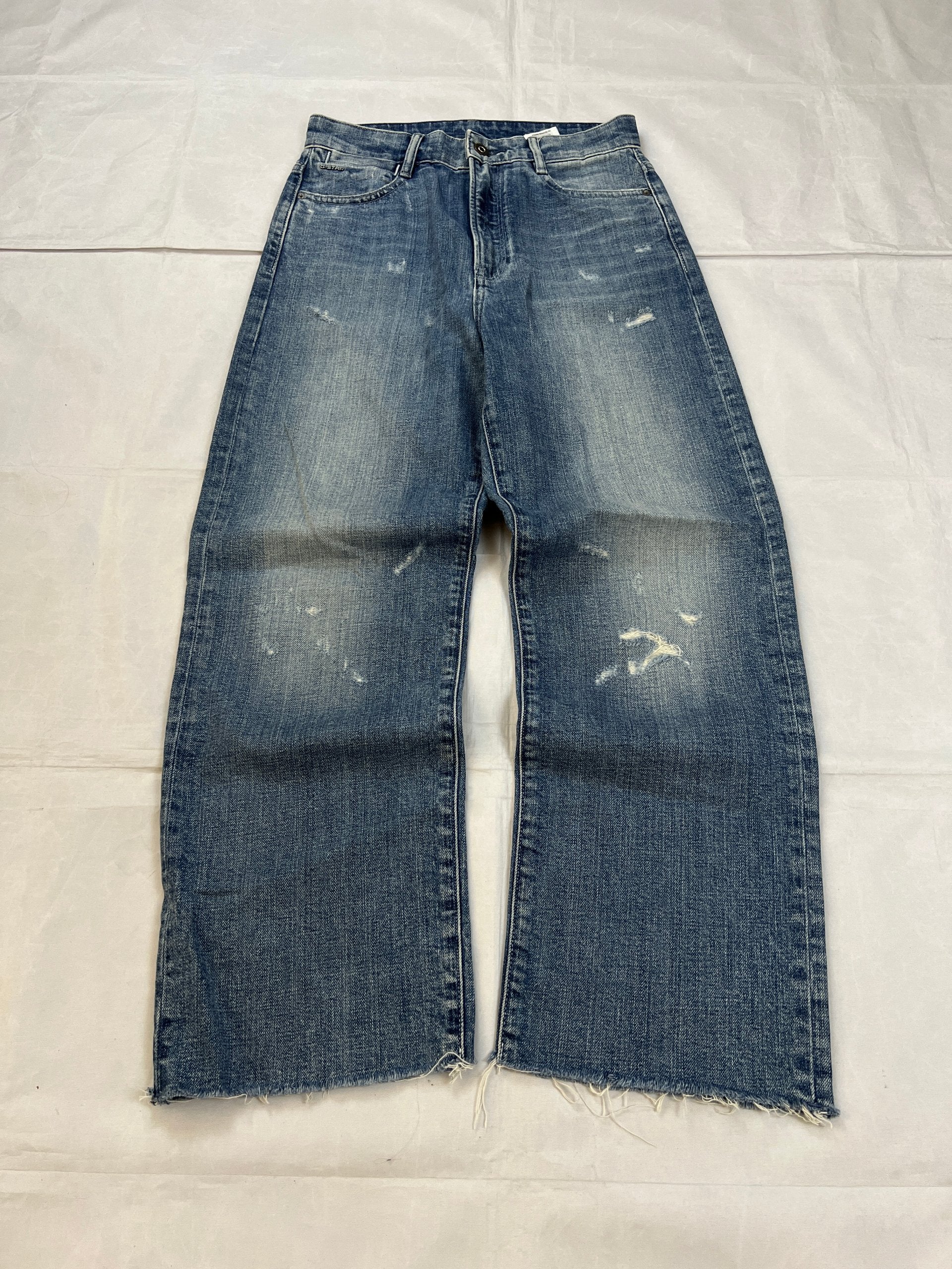 G-Star Raw blue distressed denim jeans with frayed hems and slit detail.