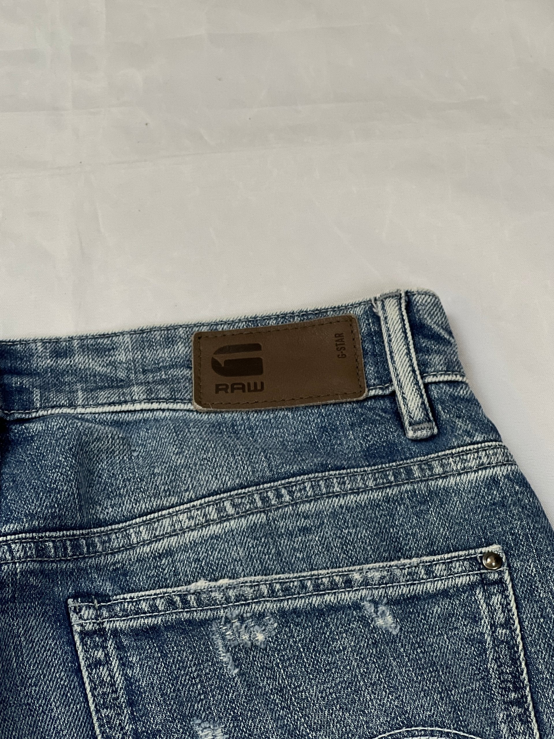 G-Star Raw blue distressed denim jeans with frayed hems and slit detail.