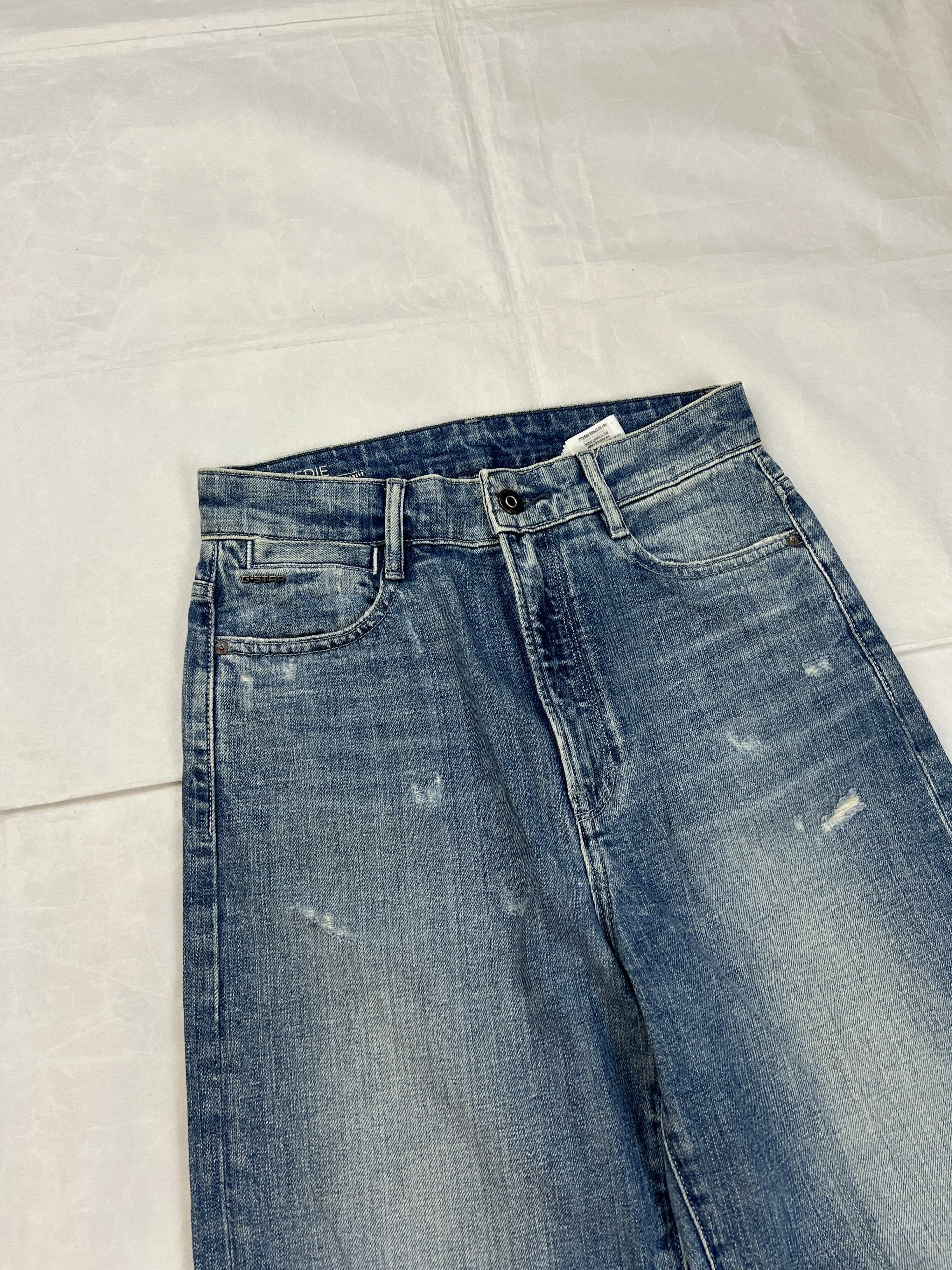 G-Star Raw blue distressed denim jeans with frayed hems and slit detail.