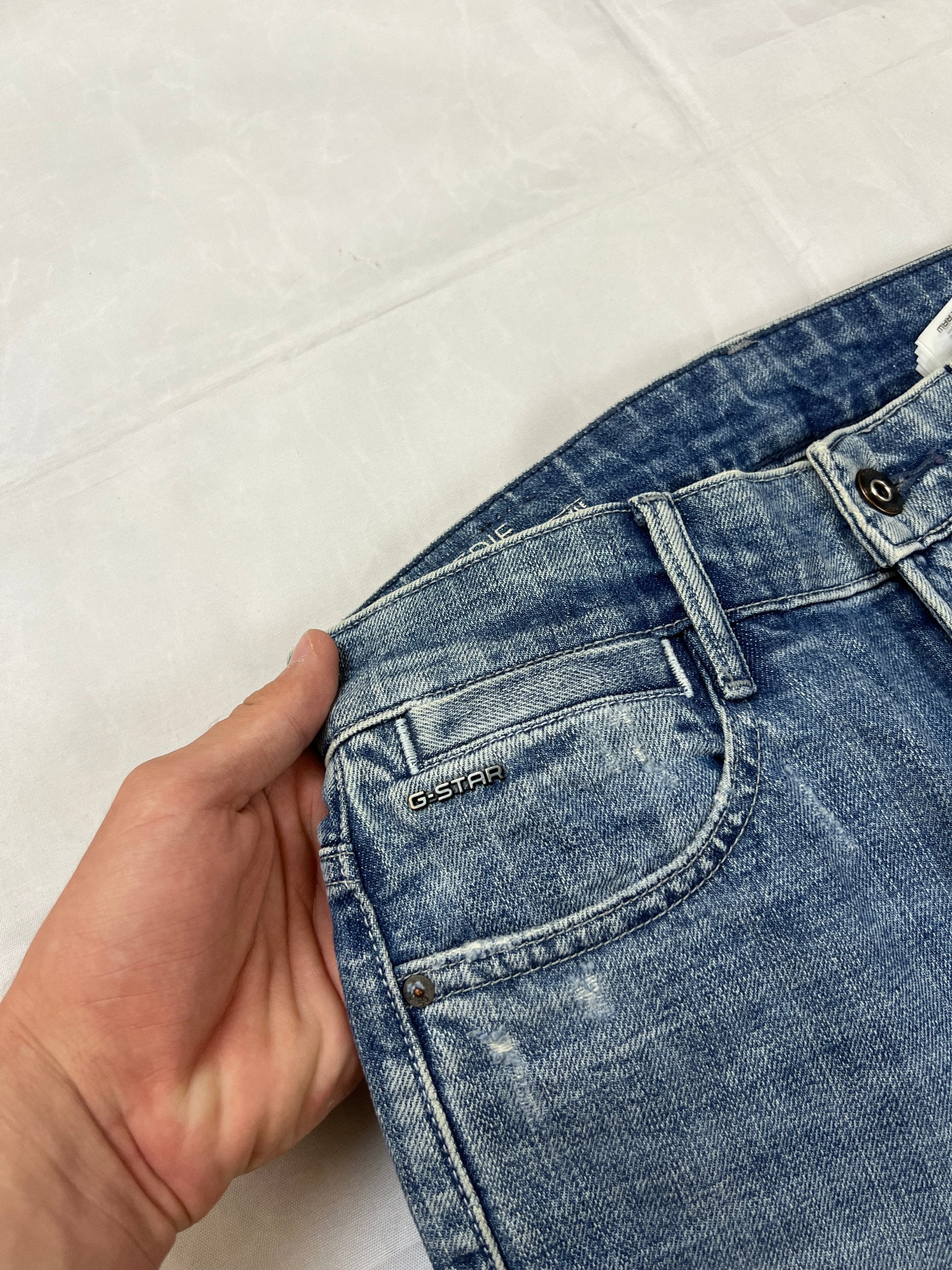G-Star Raw blue distressed denim jeans with frayed hems and slit detail.