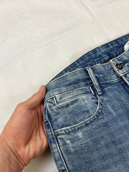 G-Star Raw blue distressed denim jeans with frayed hems and slit detail.