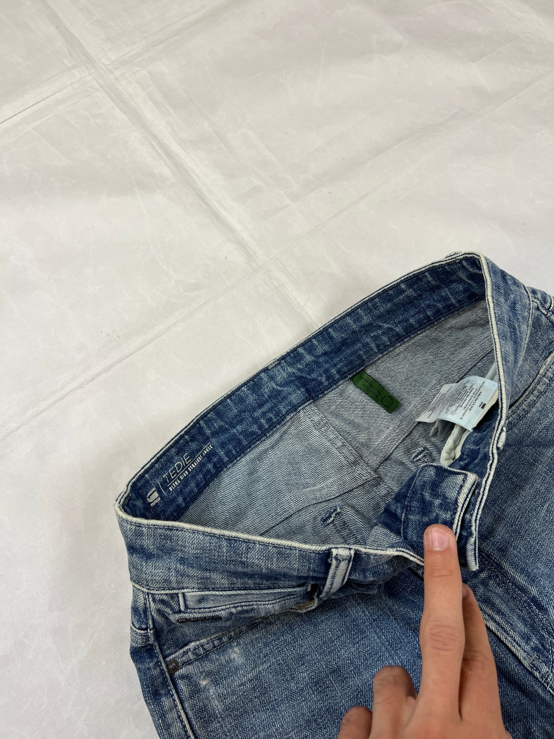 G-Star Raw blue distressed denim jeans with frayed hems and slit detail.