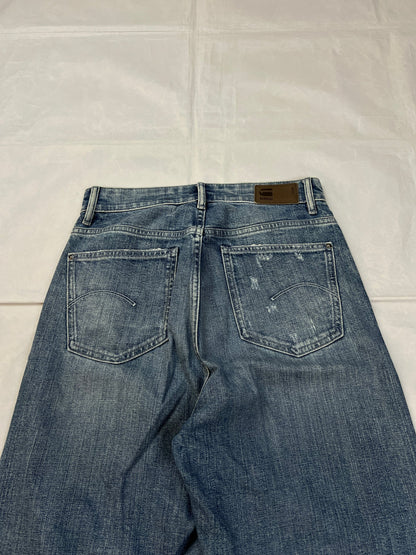 G-Star Raw blue distressed denim jeans with frayed hems and slit detail.