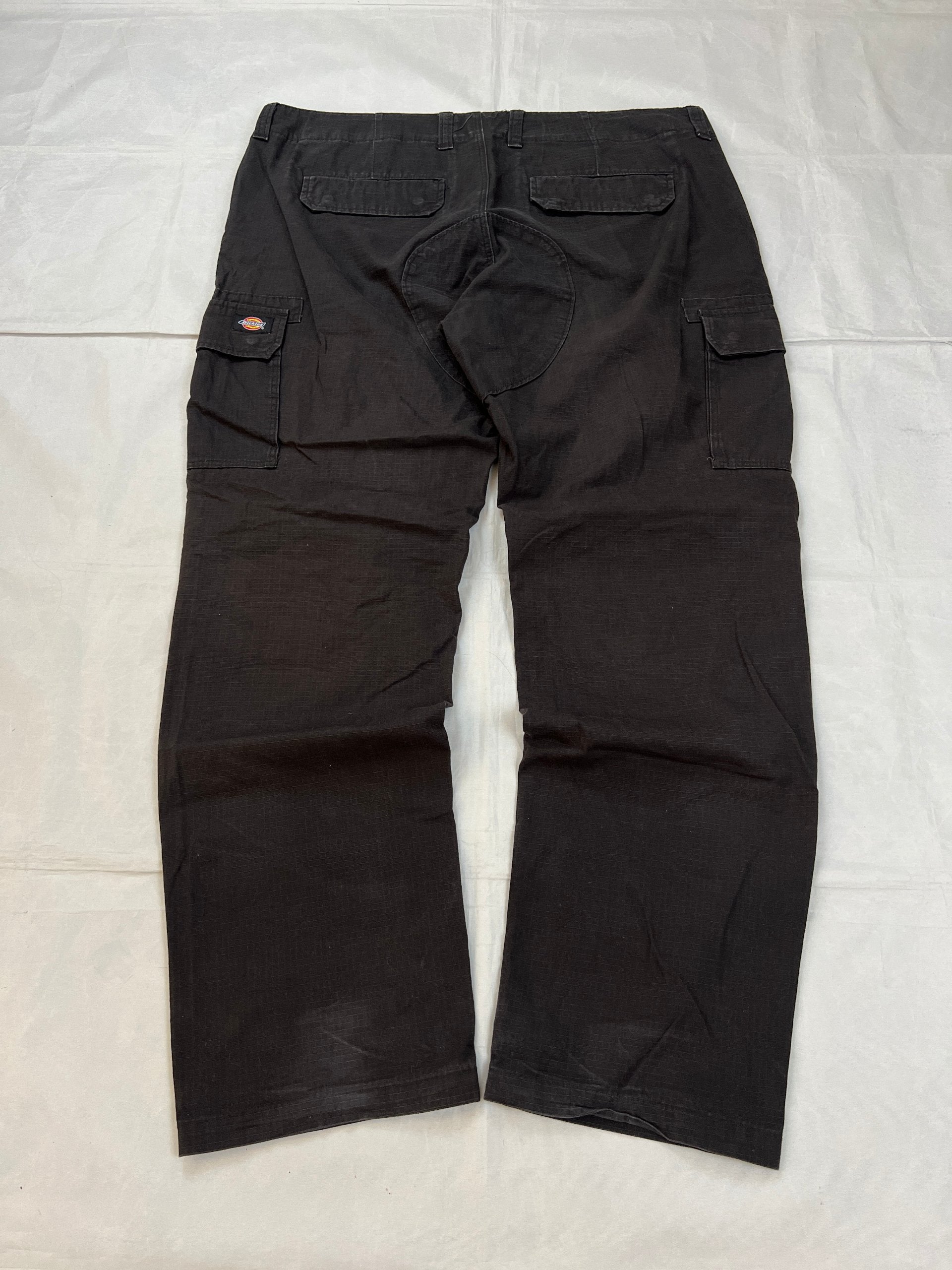 Dickies black cargo trousers with functional snap pockets and reinforced seat patch.