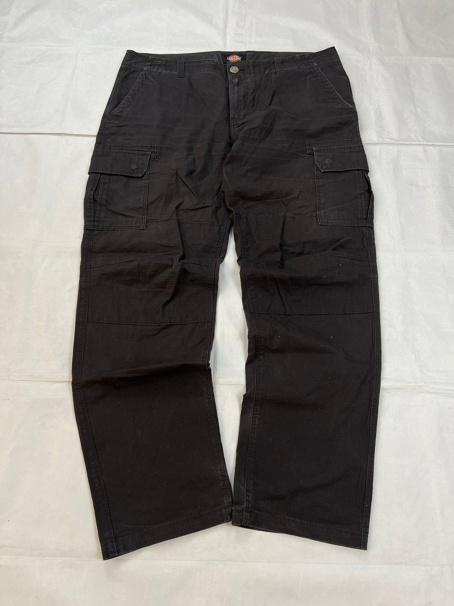 Dickies black cargo trousers with functional snap pockets and reinforced seat patch.