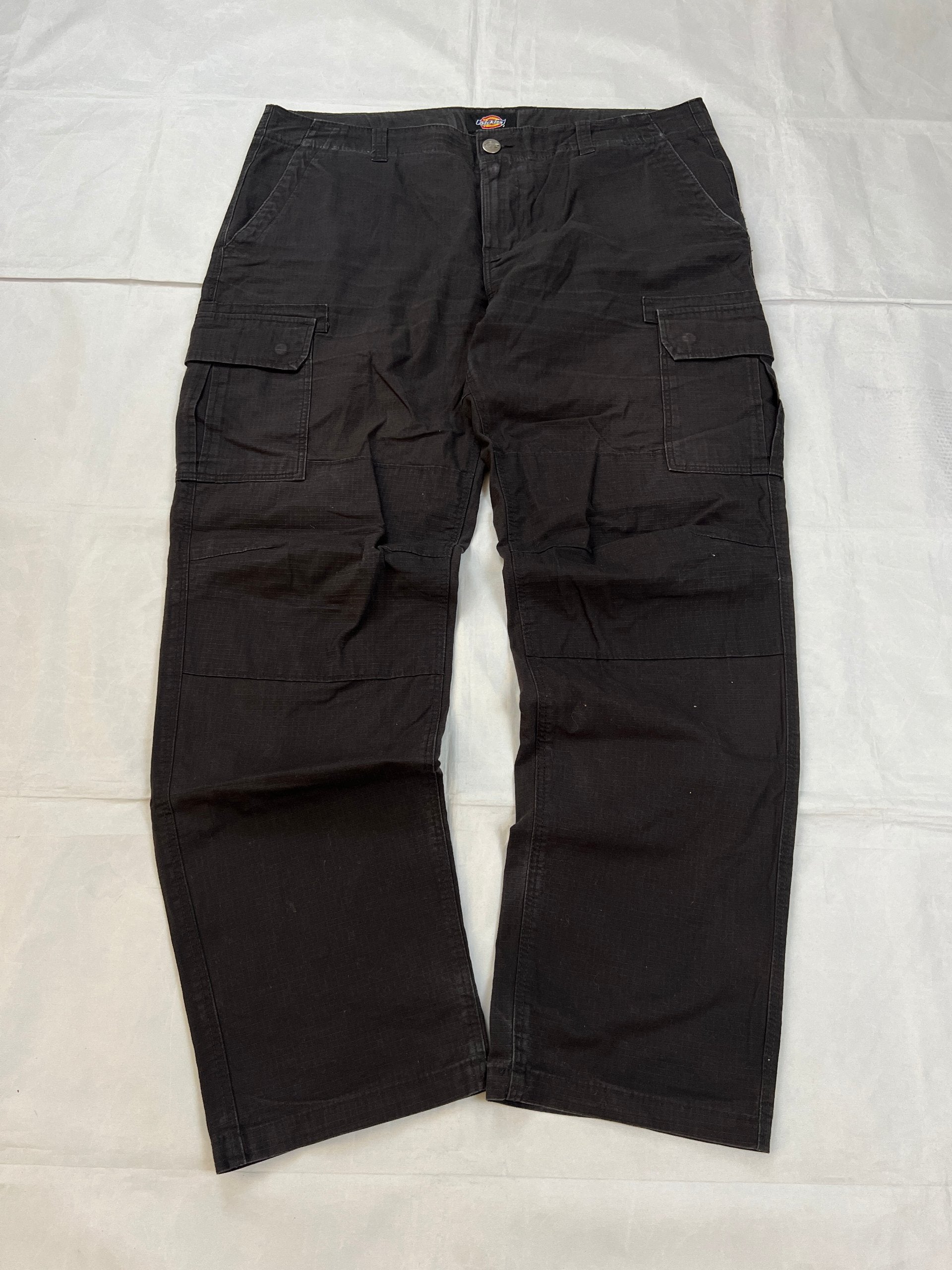 Dickies black cargo trousers with functional snap pockets and reinforced seat patch.