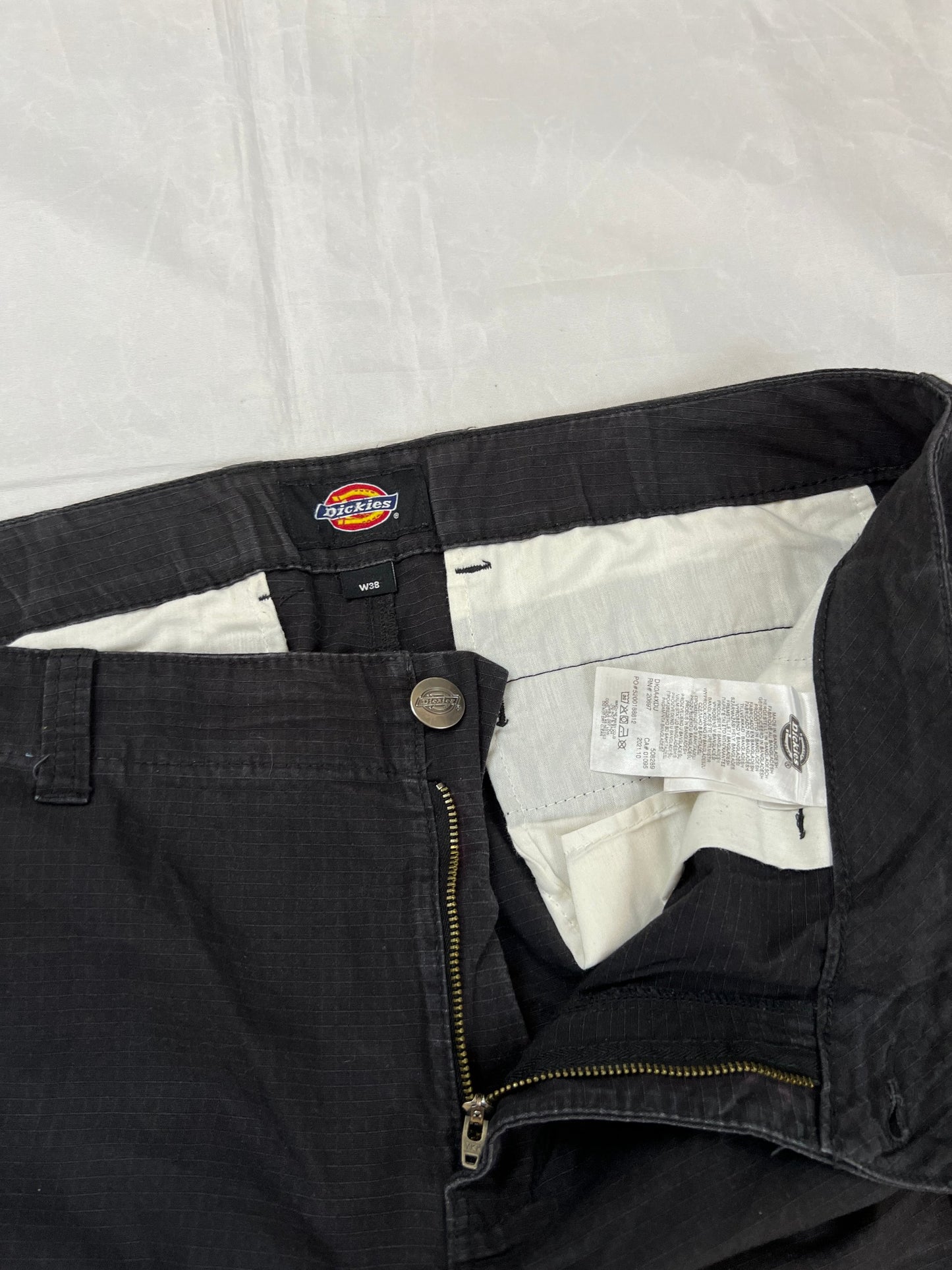 Dickies black cargo trousers with functional snap pockets and reinforced seat patch.