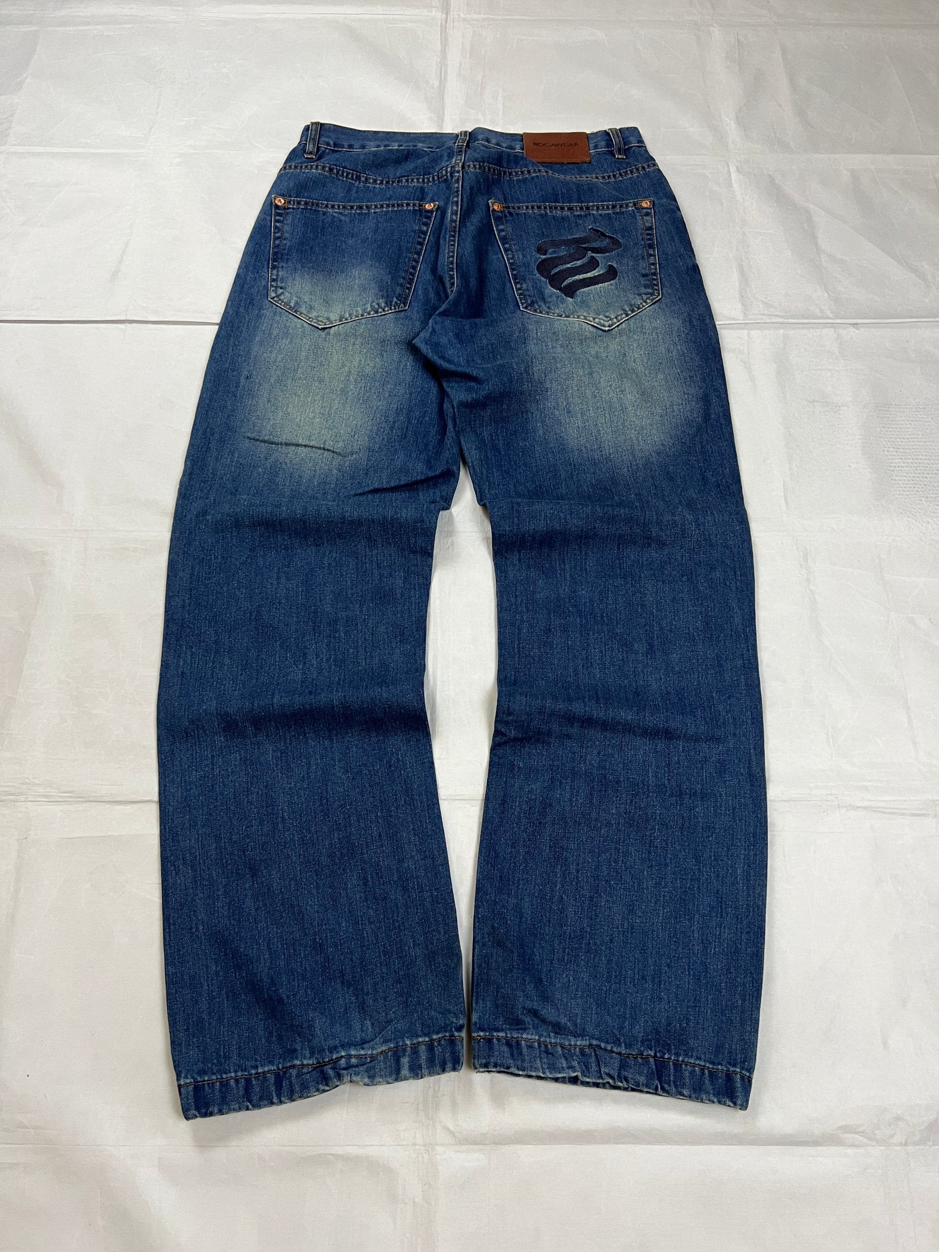 Rocawear blue denim loose fit jeans with faded effect and embroidered back pocket details.