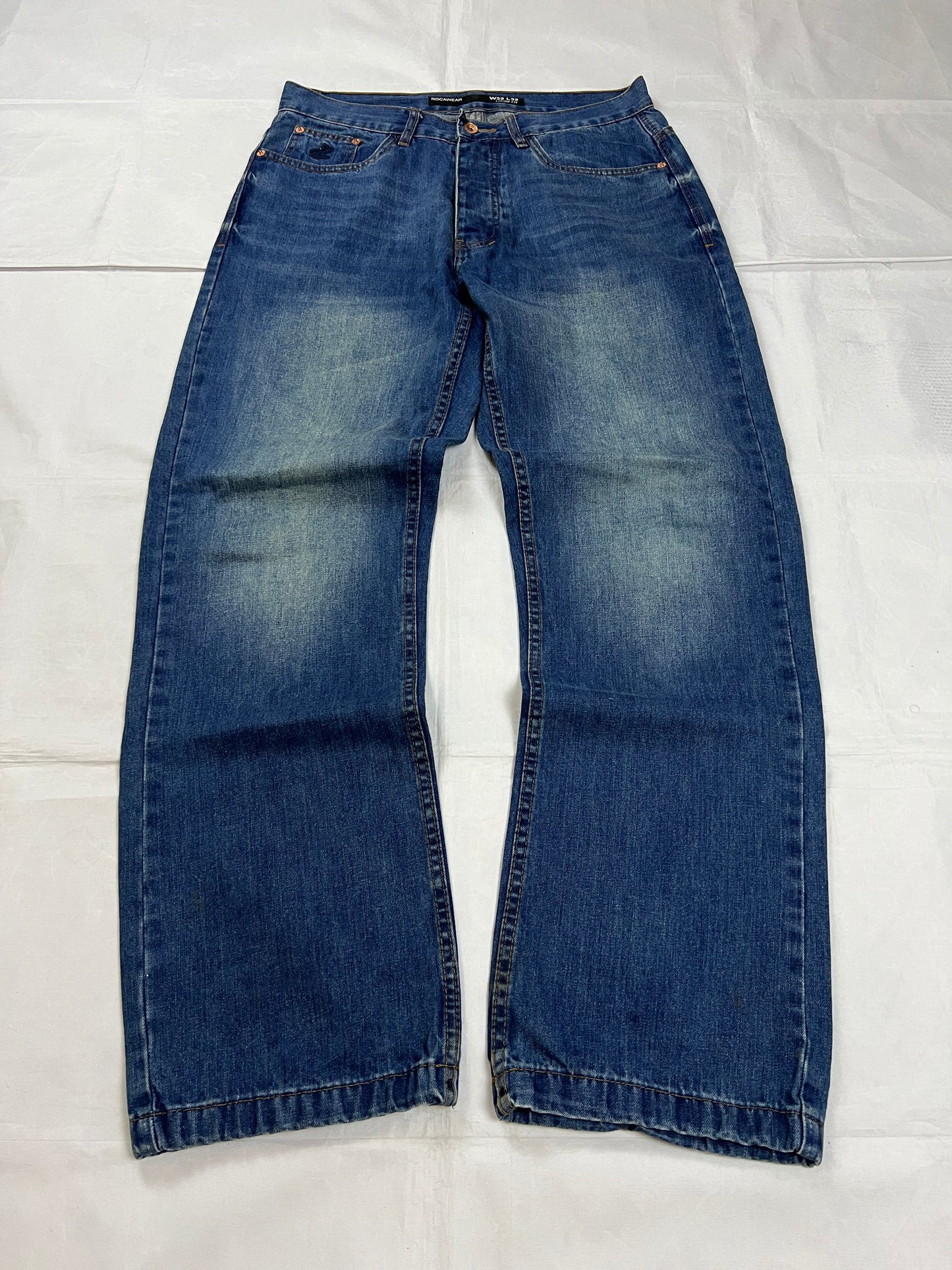 Rocawear blue denim loose fit jeans with faded effect and embroidered back pocket details.