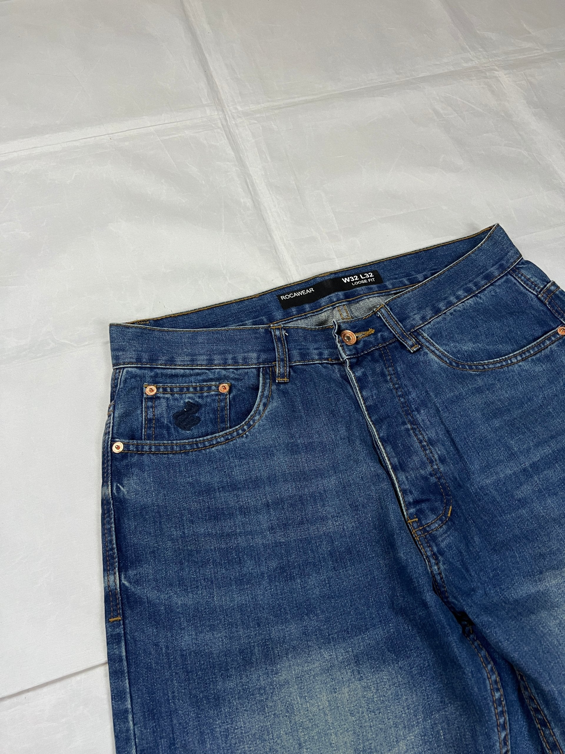 Rocawear blue denim loose fit jeans with faded effect and embroidered back pocket details.