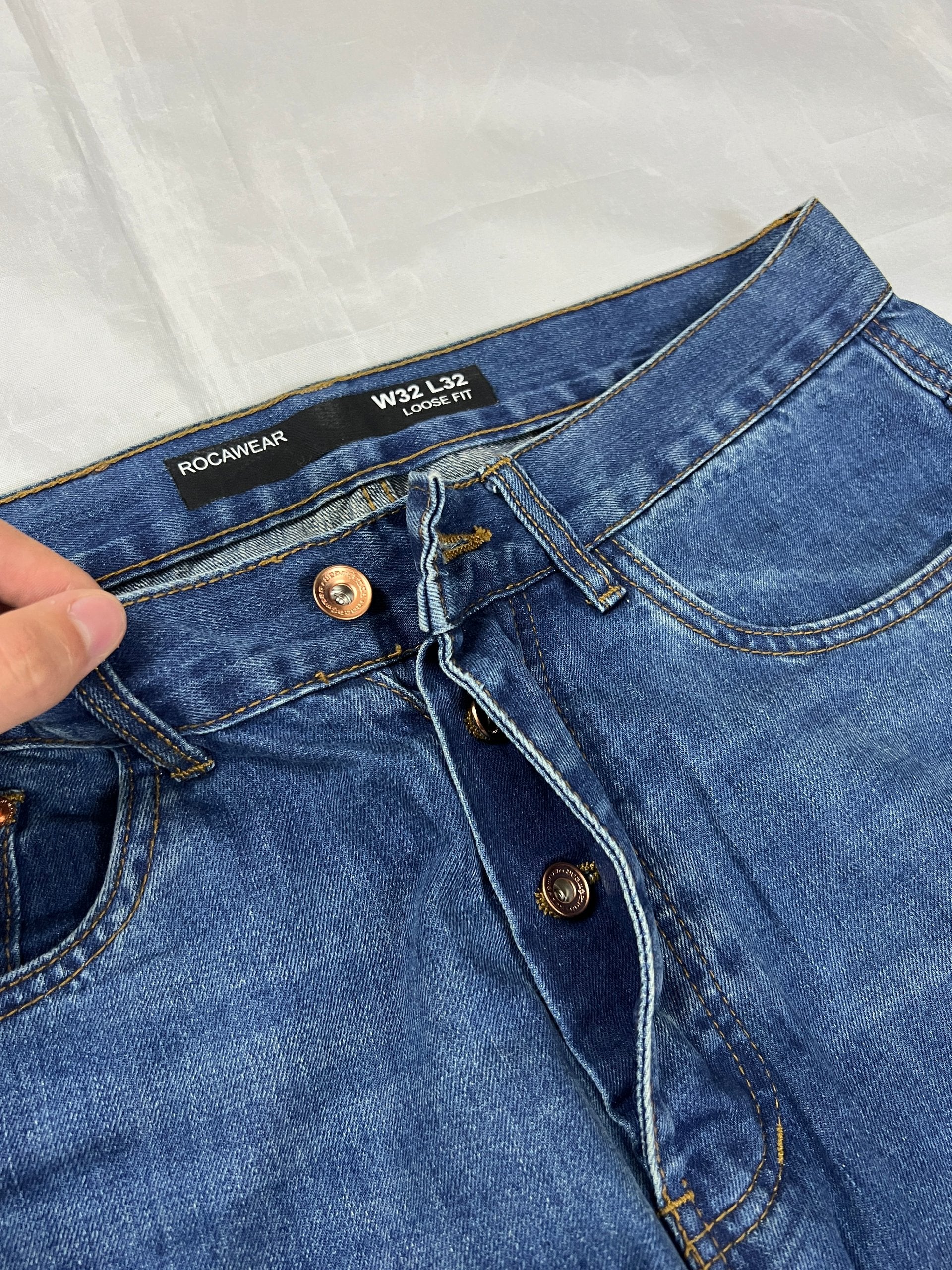 Rocawear blue denim loose fit jeans with faded effect and embroidered back pocket details.