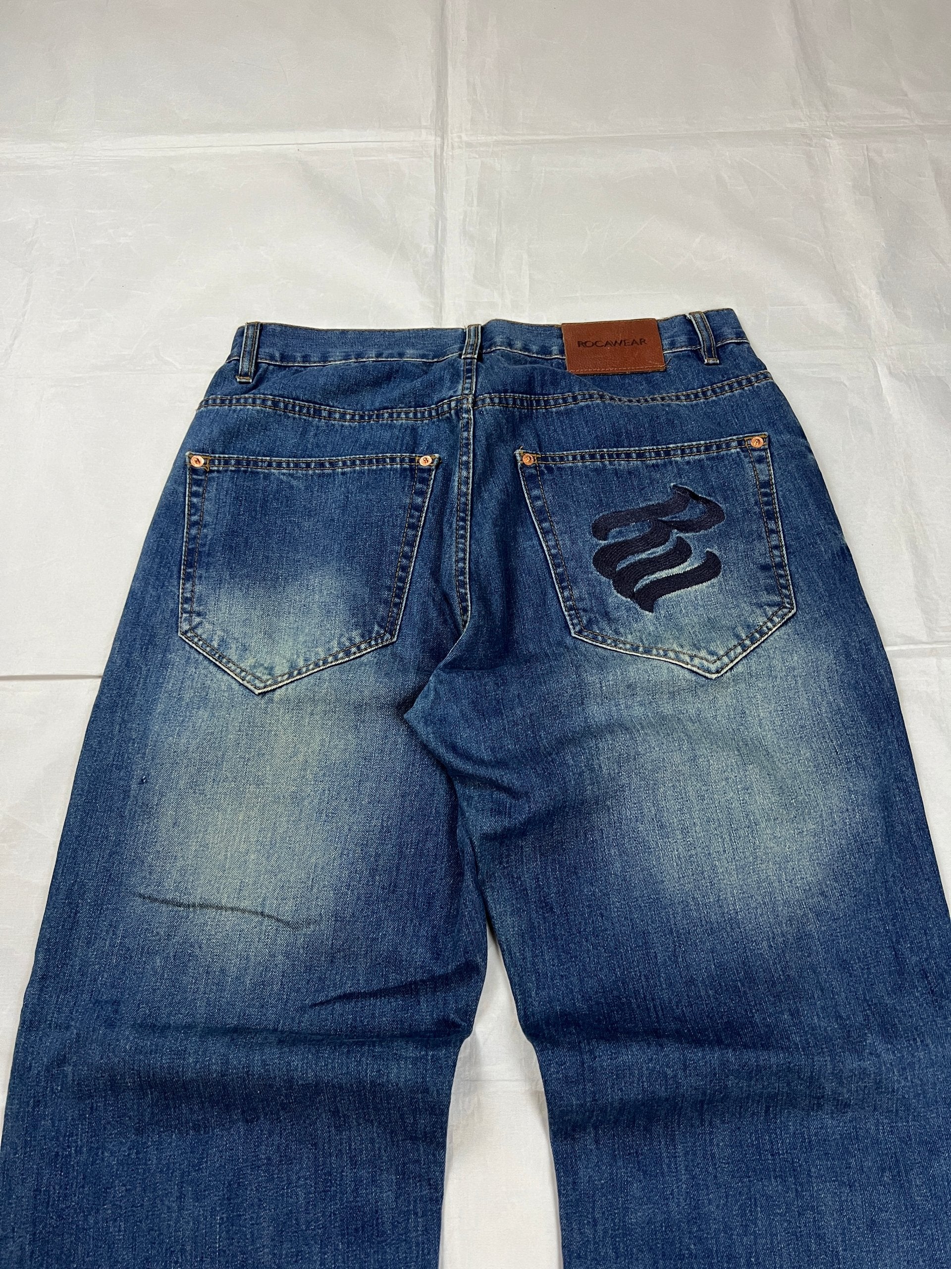 Rocawear blue denim loose fit jeans with faded effect and embroidered back pocket details.