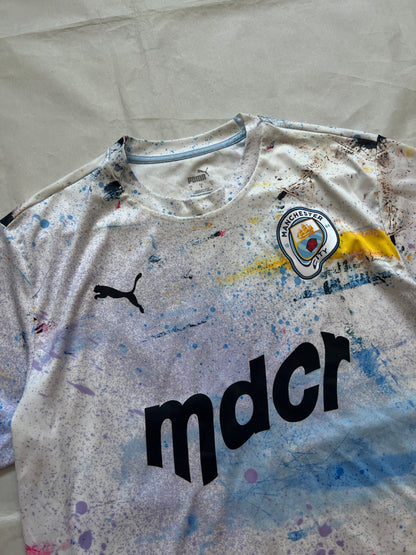 Puma blue and white football jersey with Manchester City crest and splatter paint design.