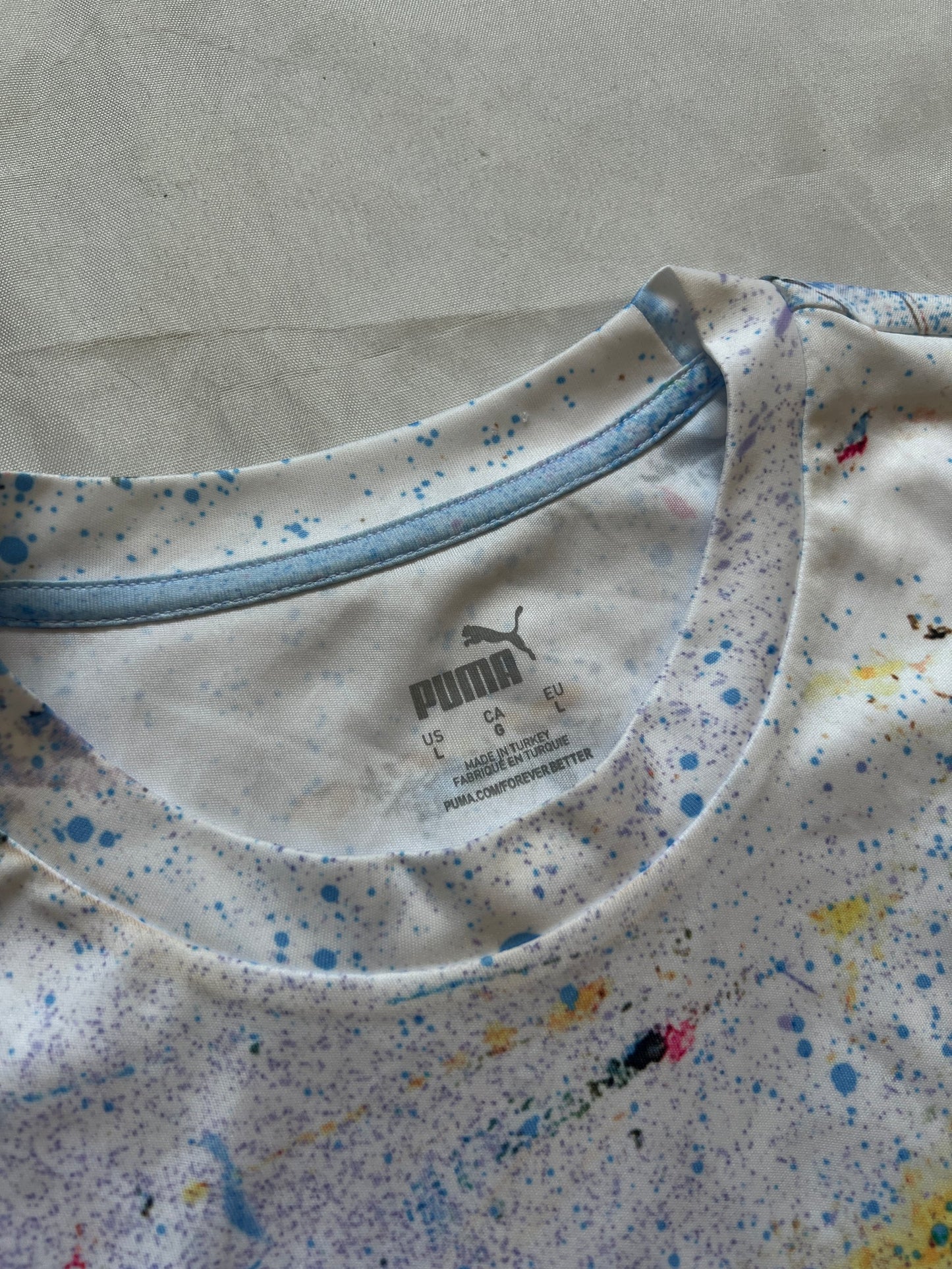 Puma blue and white football jersey with Manchester City crest and splatter paint design.