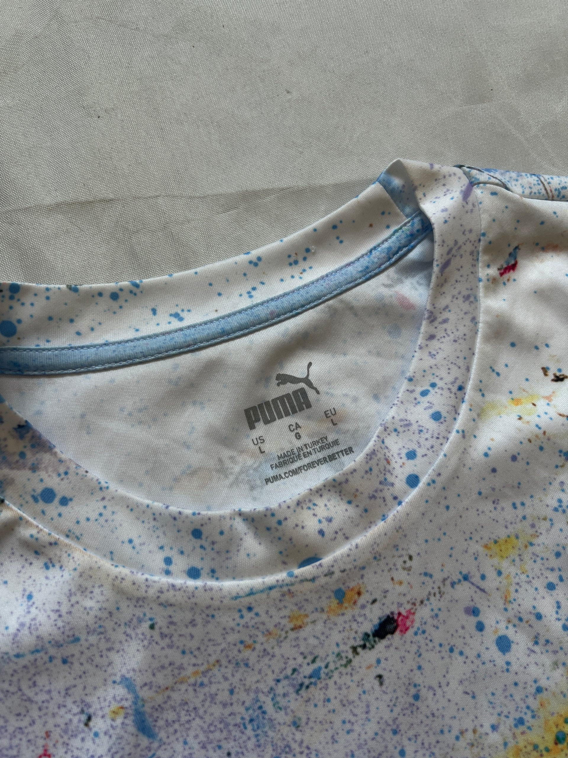 Puma blue and white football jersey with Manchester City crest and splatter paint design.