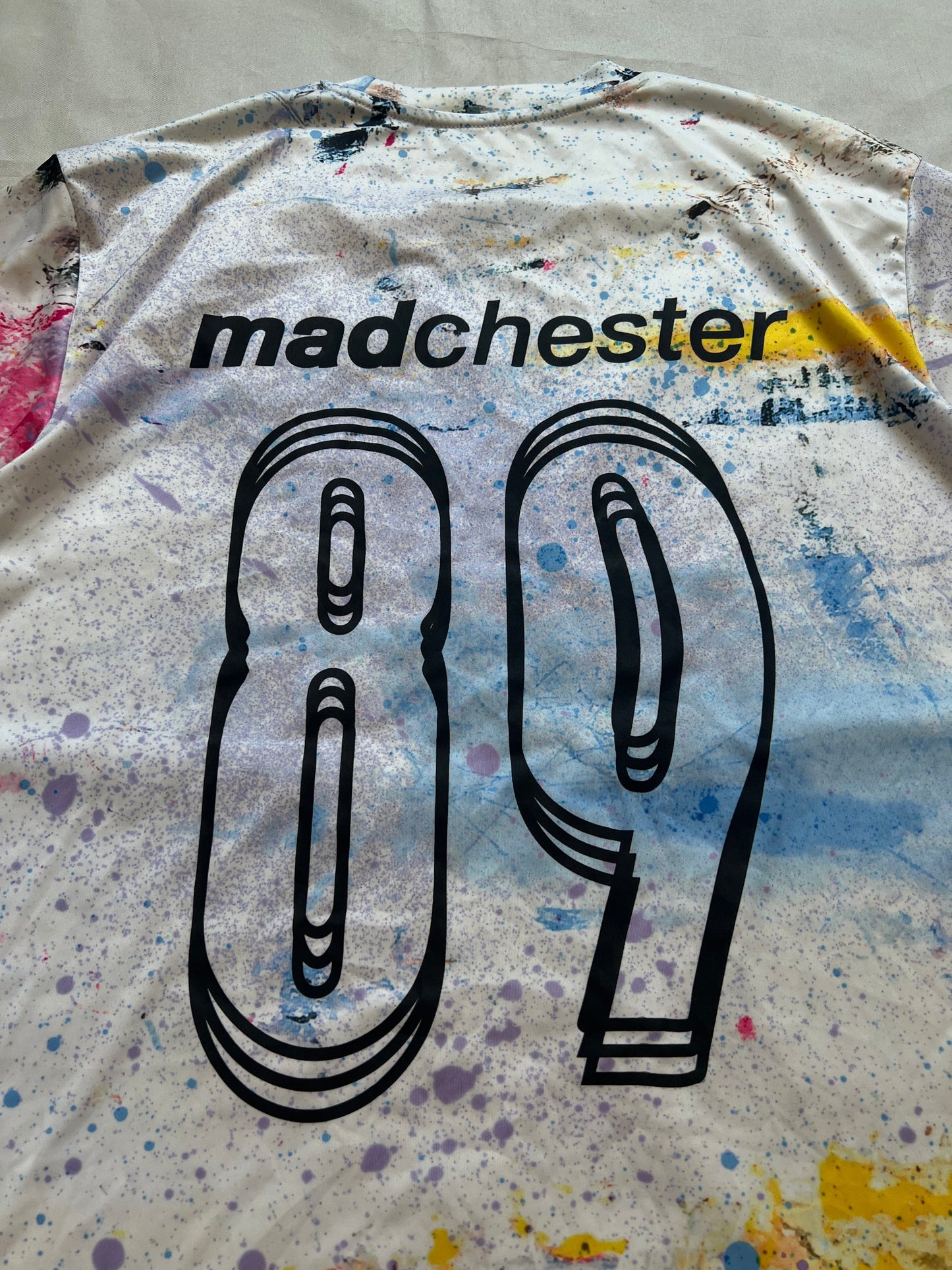 Puma blue and white football jersey with Manchester City crest and splatter paint design.