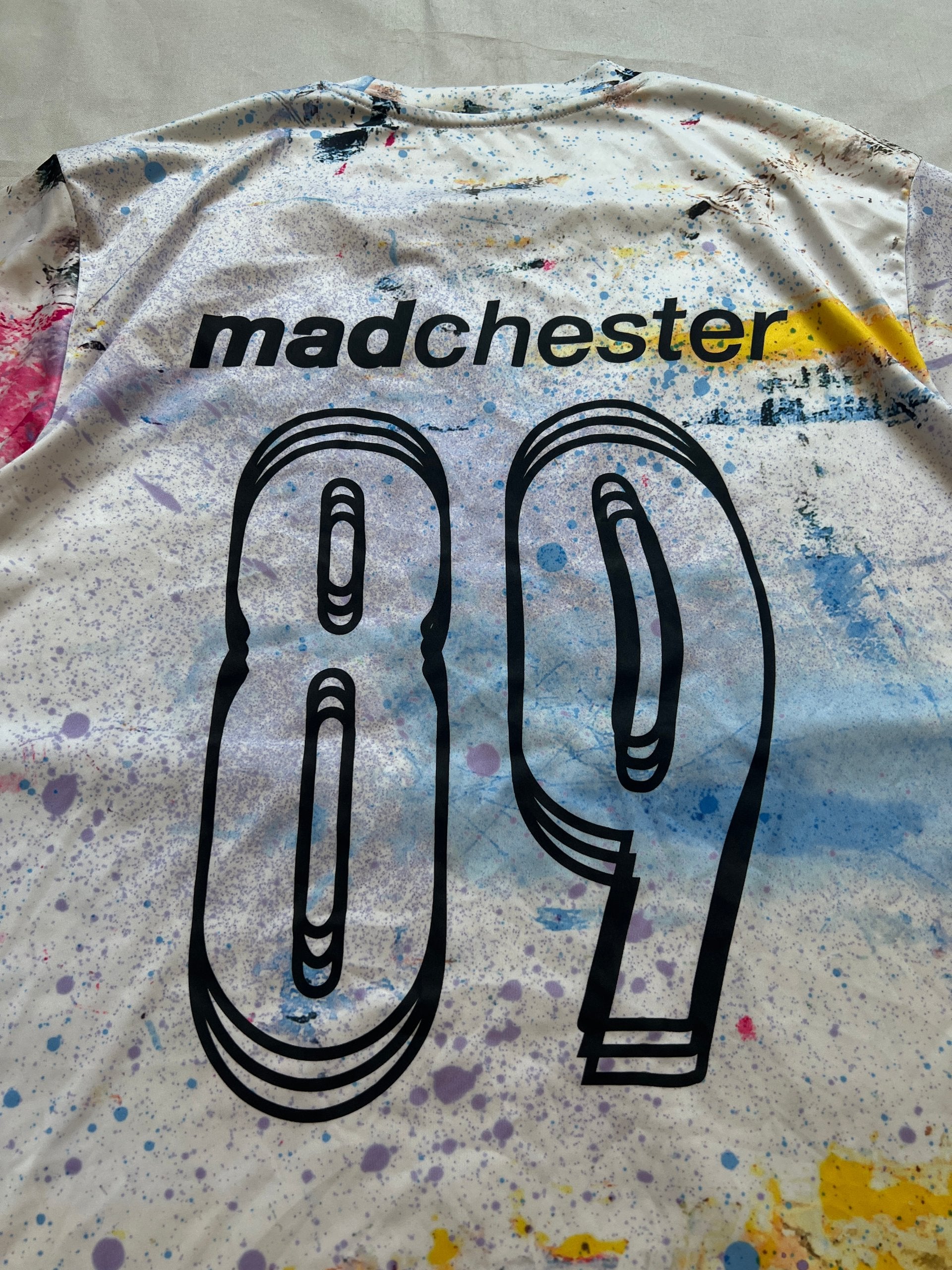 Puma blue and white football jersey with Manchester City crest and splatter paint design.