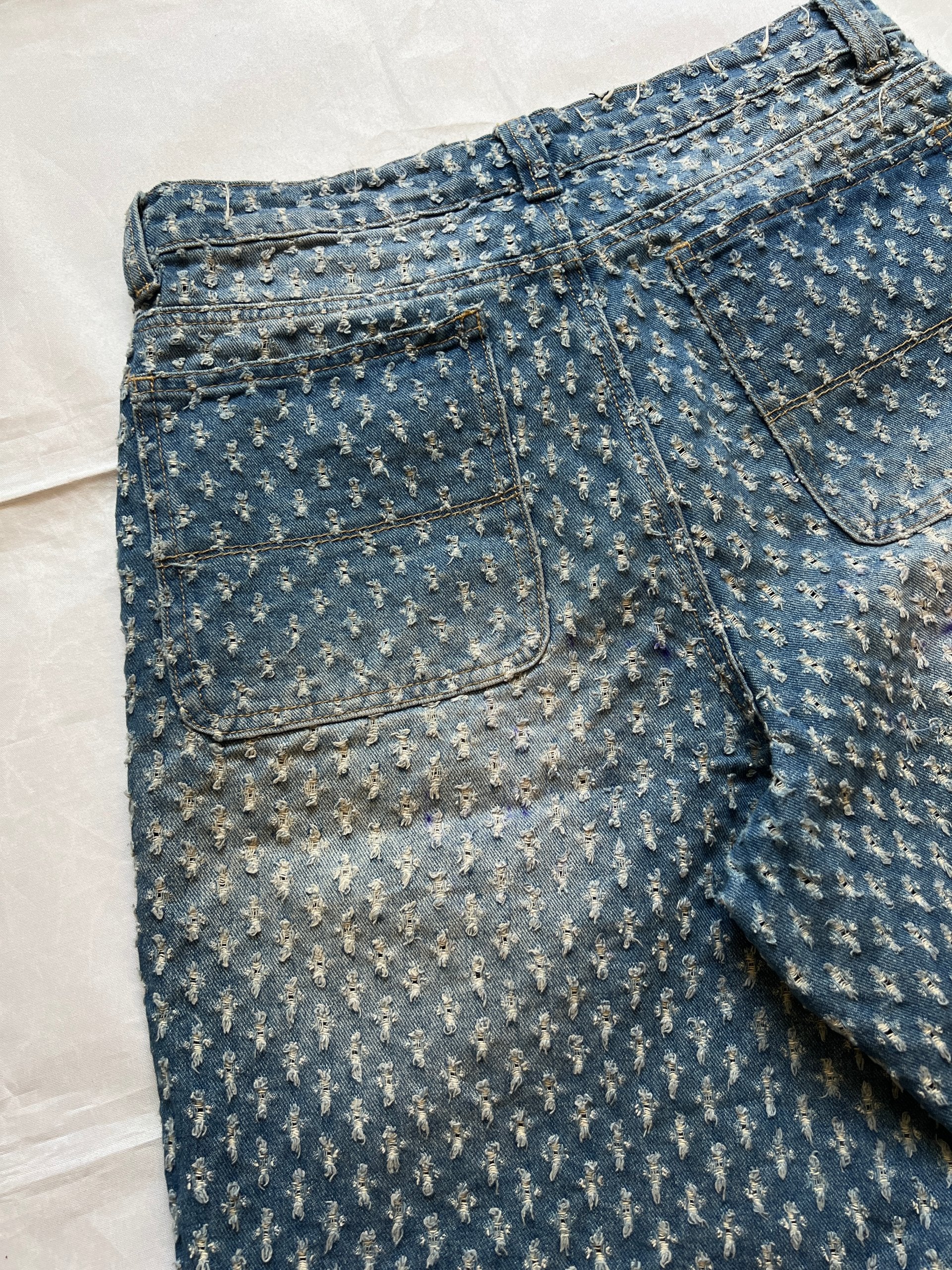 Based NY blue baggy fit denim shorts with distressed pattern and brass rivet details.