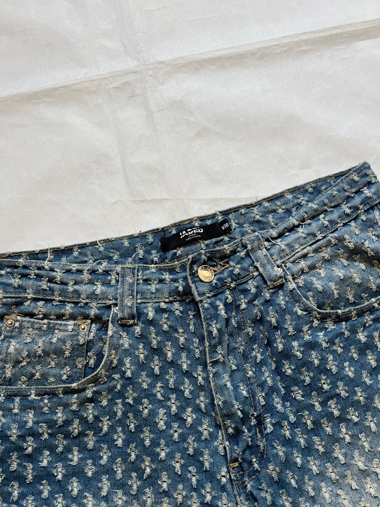 Based NY blue baggy fit denim shorts with distressed pattern and brass rivet details.