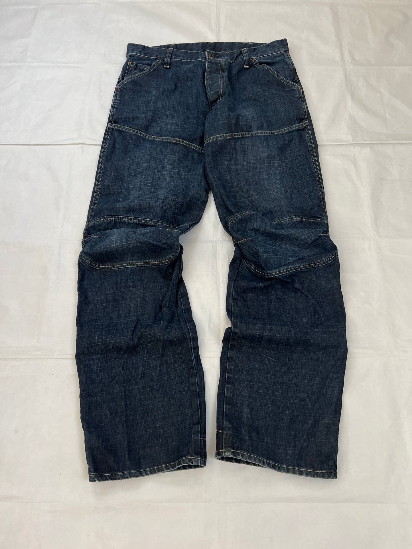 G-Star Raw blue denim jeans with embroidered logo, distinctive seam detailing, and large back pockets.