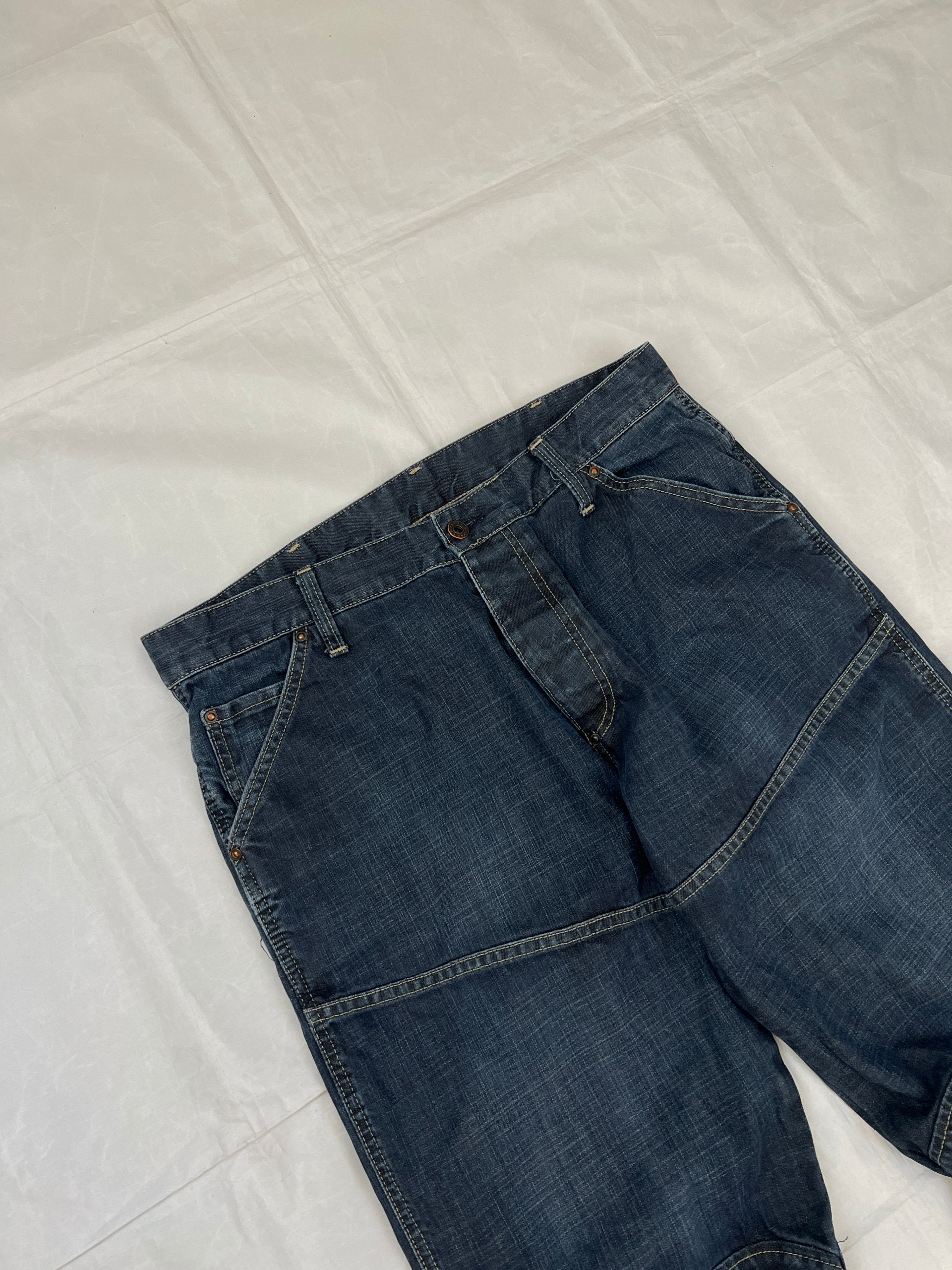 G-Star Raw blue denim jeans with embroidered logo, distinctive seam detailing, and large back pockets.