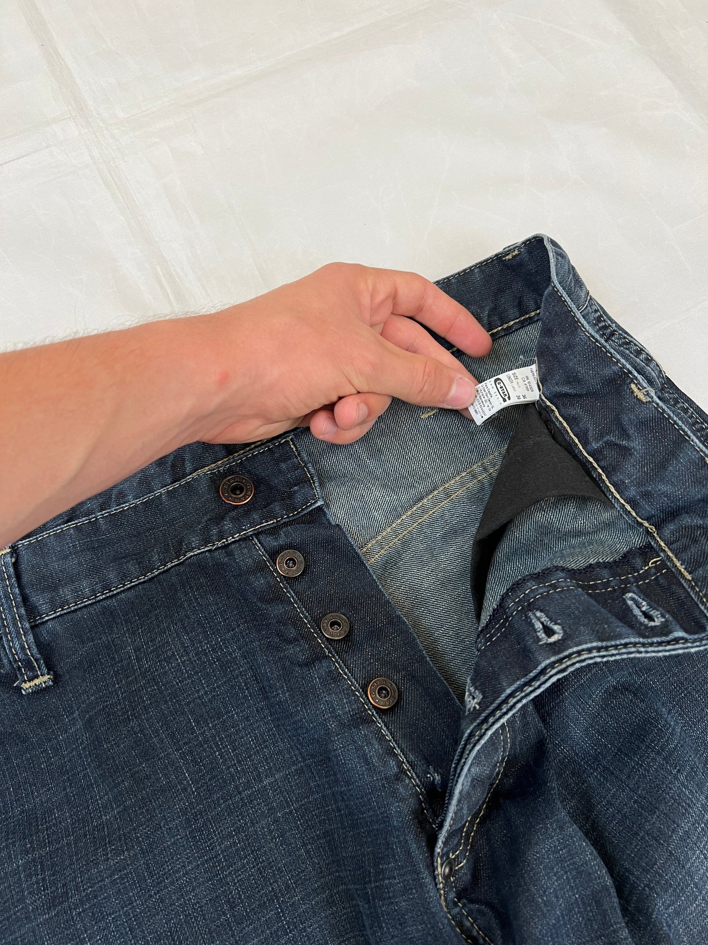 G-Star Raw blue denim jeans with embroidered logo, distinctive seam detailing, and large back pockets.